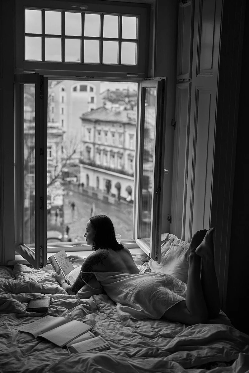Woman_Reading_by_Open_Window_in_Cozy_Bedroom.jpg