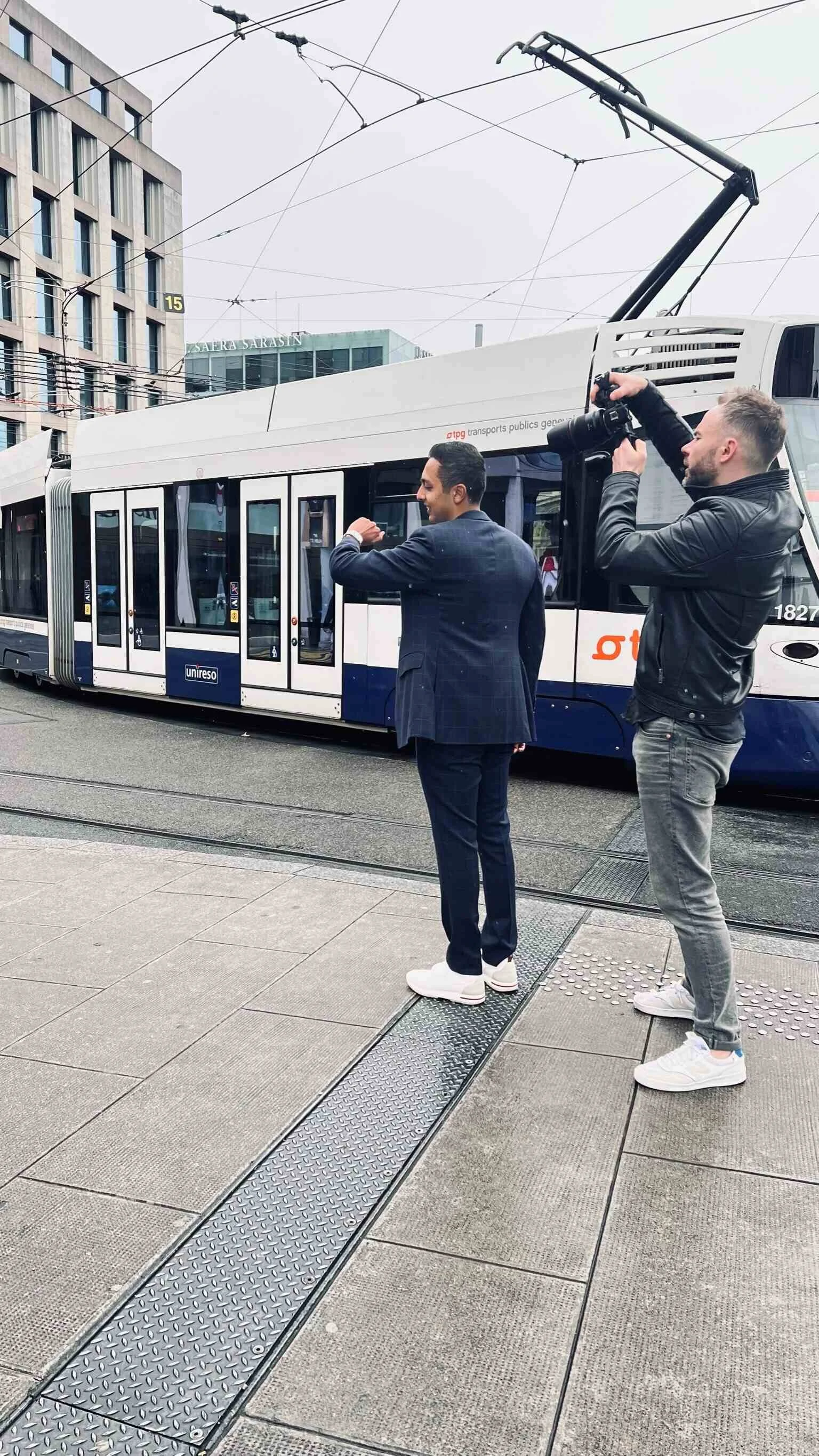 Man_in_Suit_Posing_with_Photographer_Near_Tram_in_City.jpeg