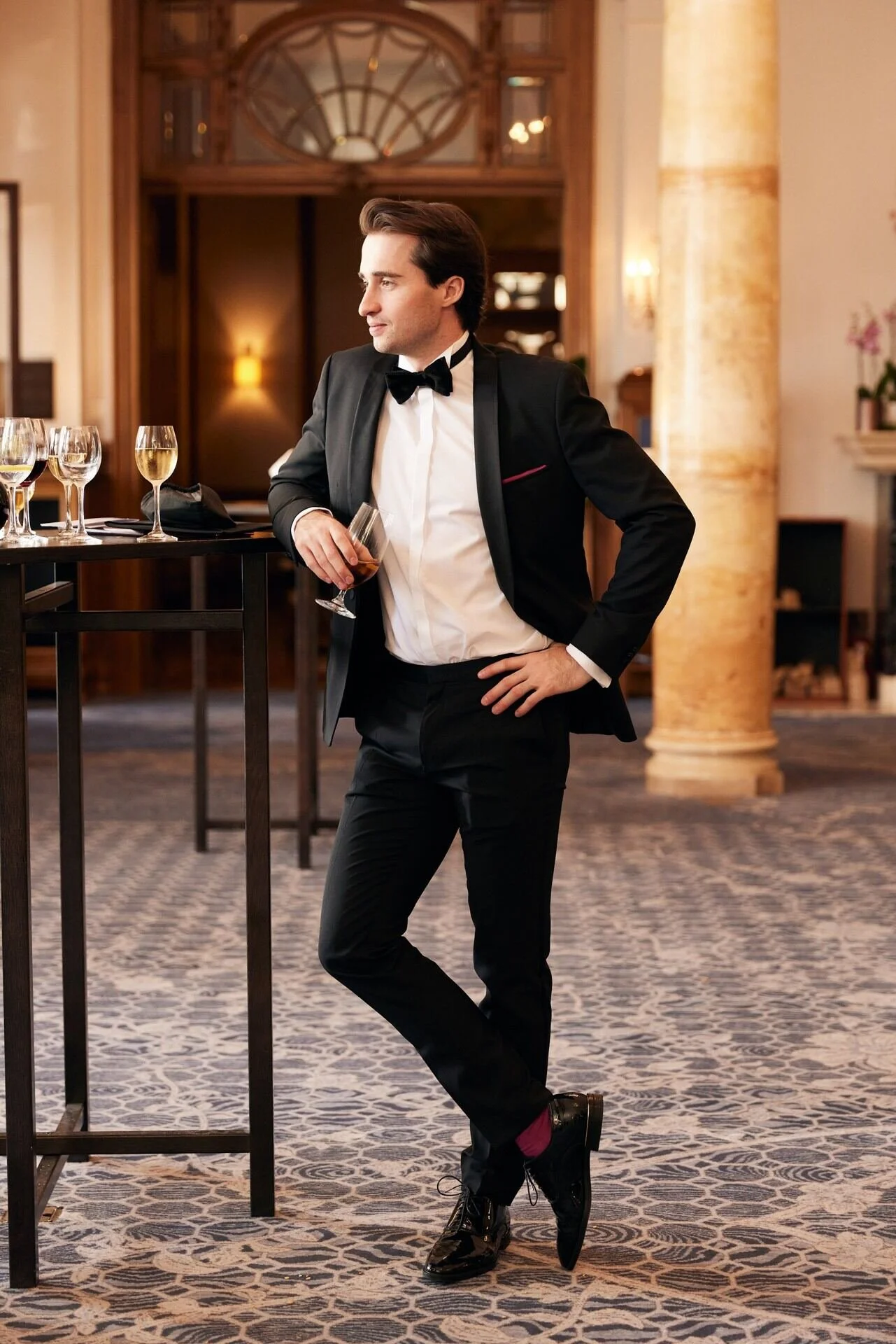 Man_in_tuxedo_with_drink_in_elegant_interior_setting.jpeg