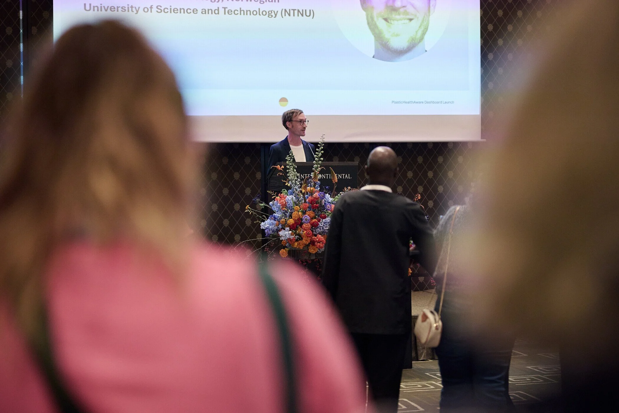 Speaker_at_Conference_with_Floral_Arrangement.jpg