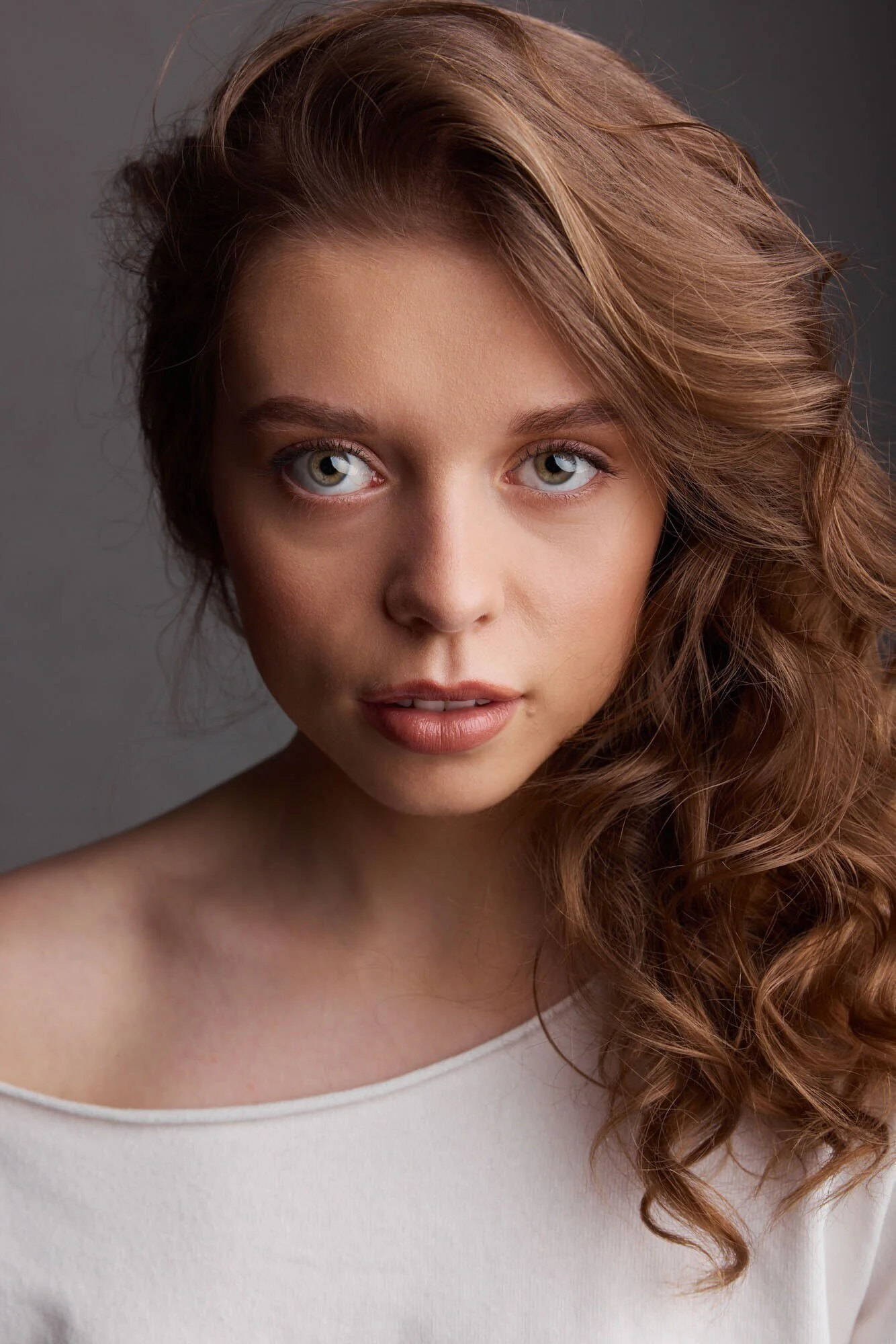 Close-up_portrait_of_a_woman_with_curly_hair_and_neutral_top.jpg