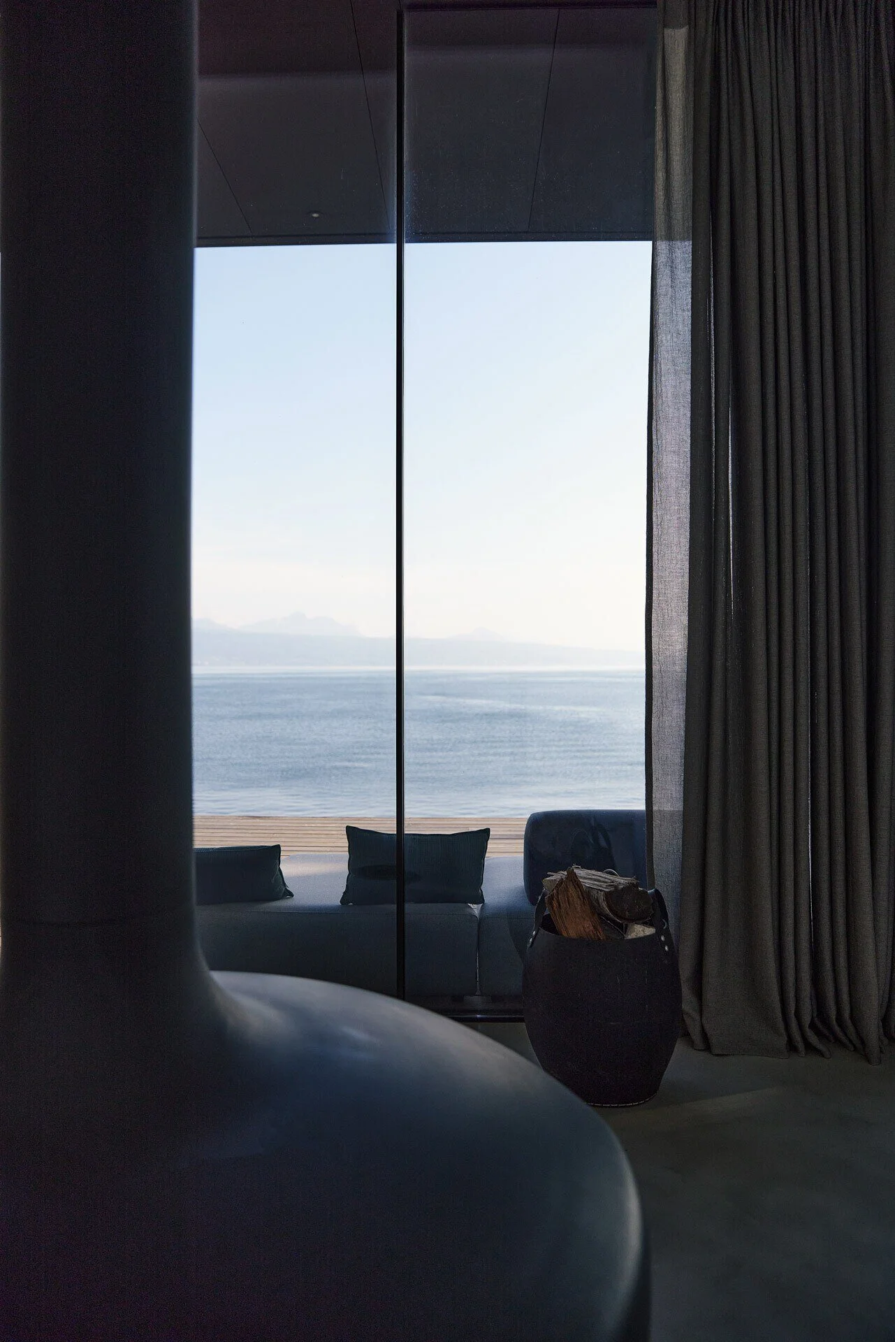 Modern_interior_with_lake_view_and_curtains.jpeg