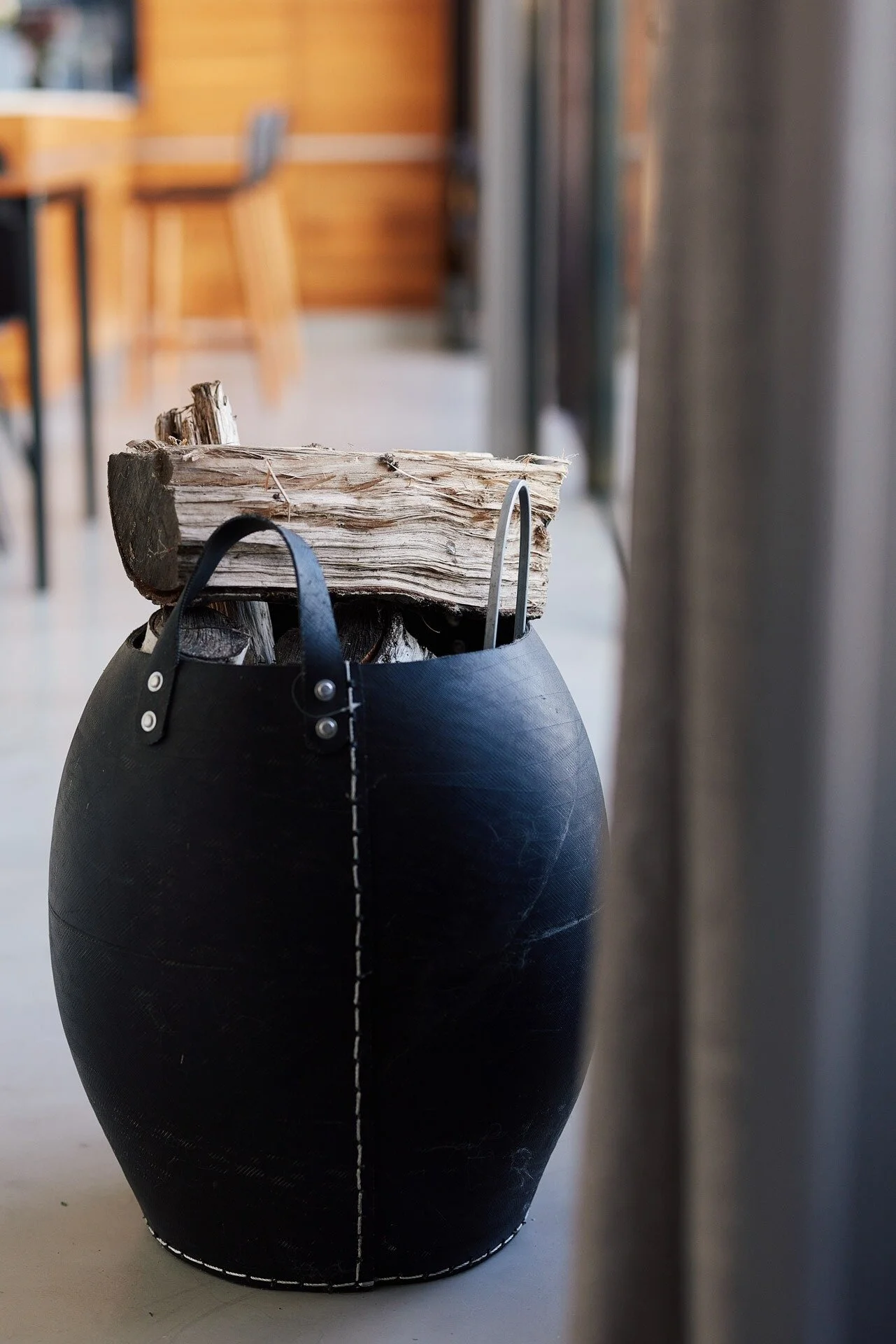 Black_barrel_with_logs_in_modern_interior_setting.jpeg