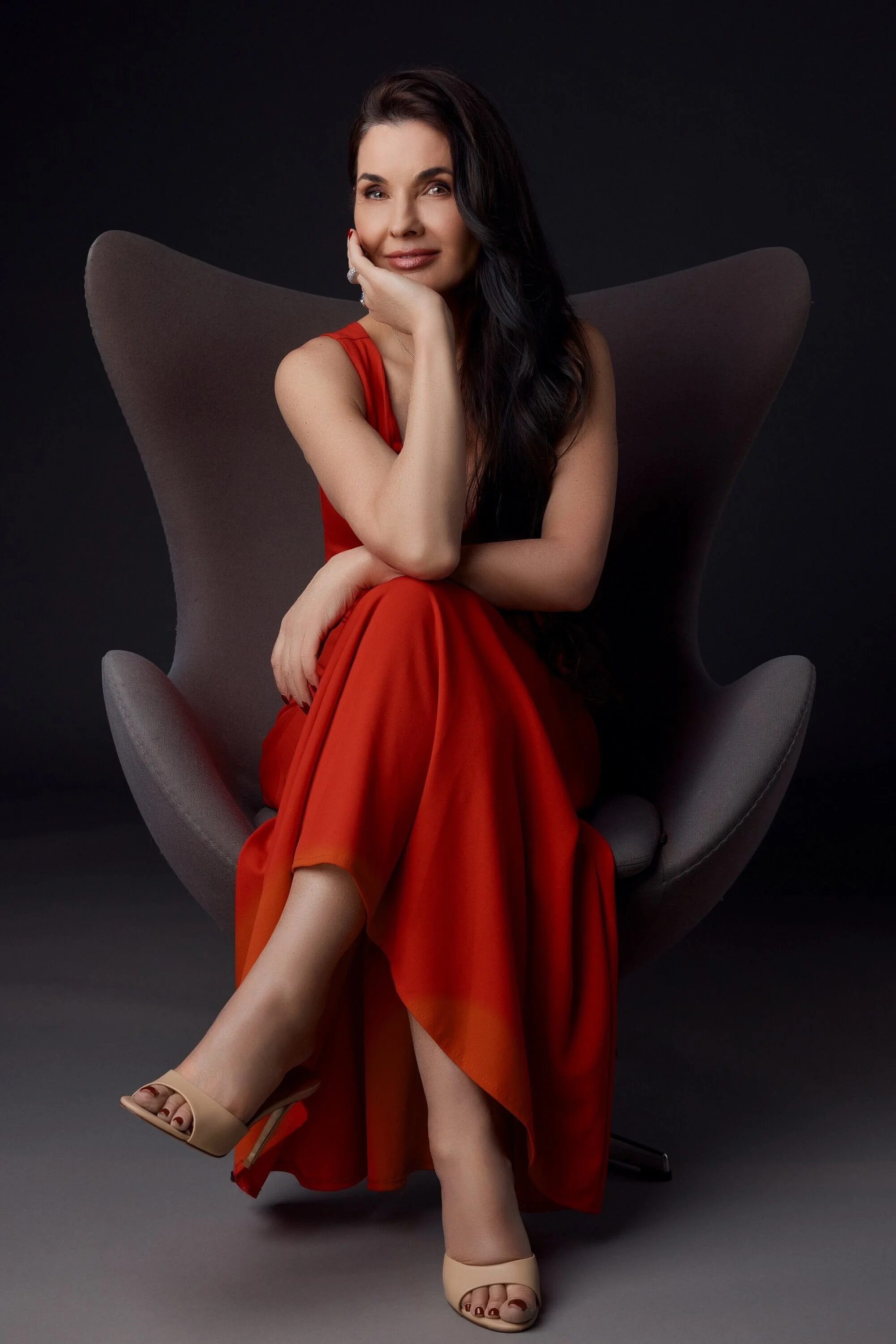 Woman_in_Red_Dress_Sitting_on_Gray_Chair.jpg