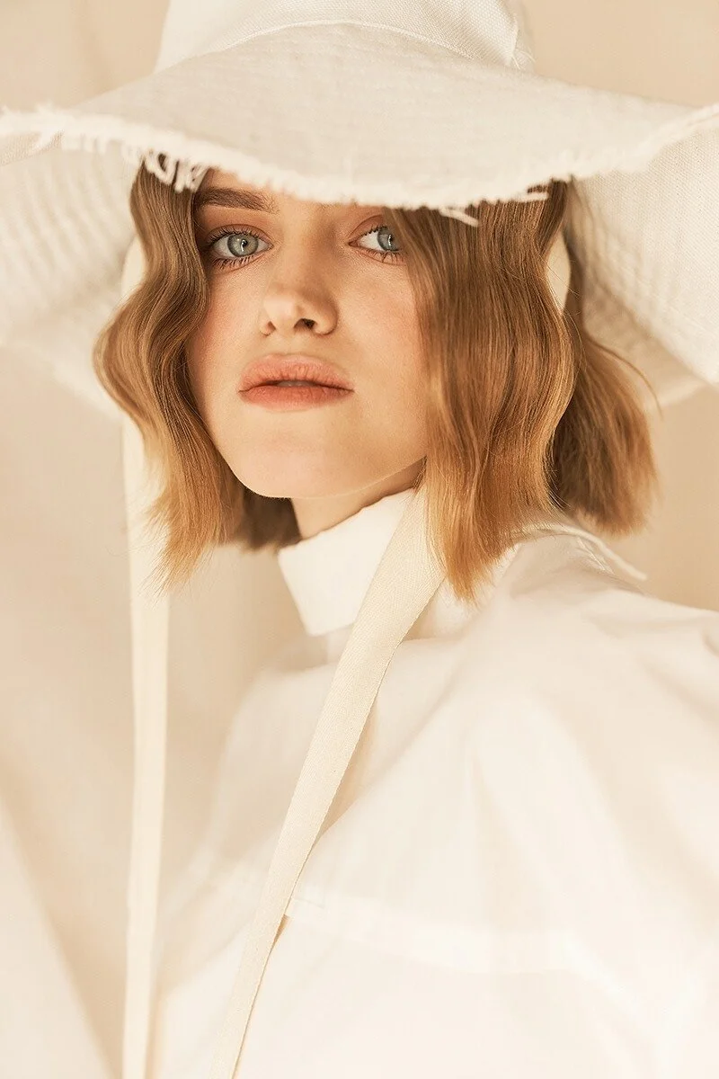 Woman_in_White_Hat_and_Blouse_with_Soft_Lighting.jpg