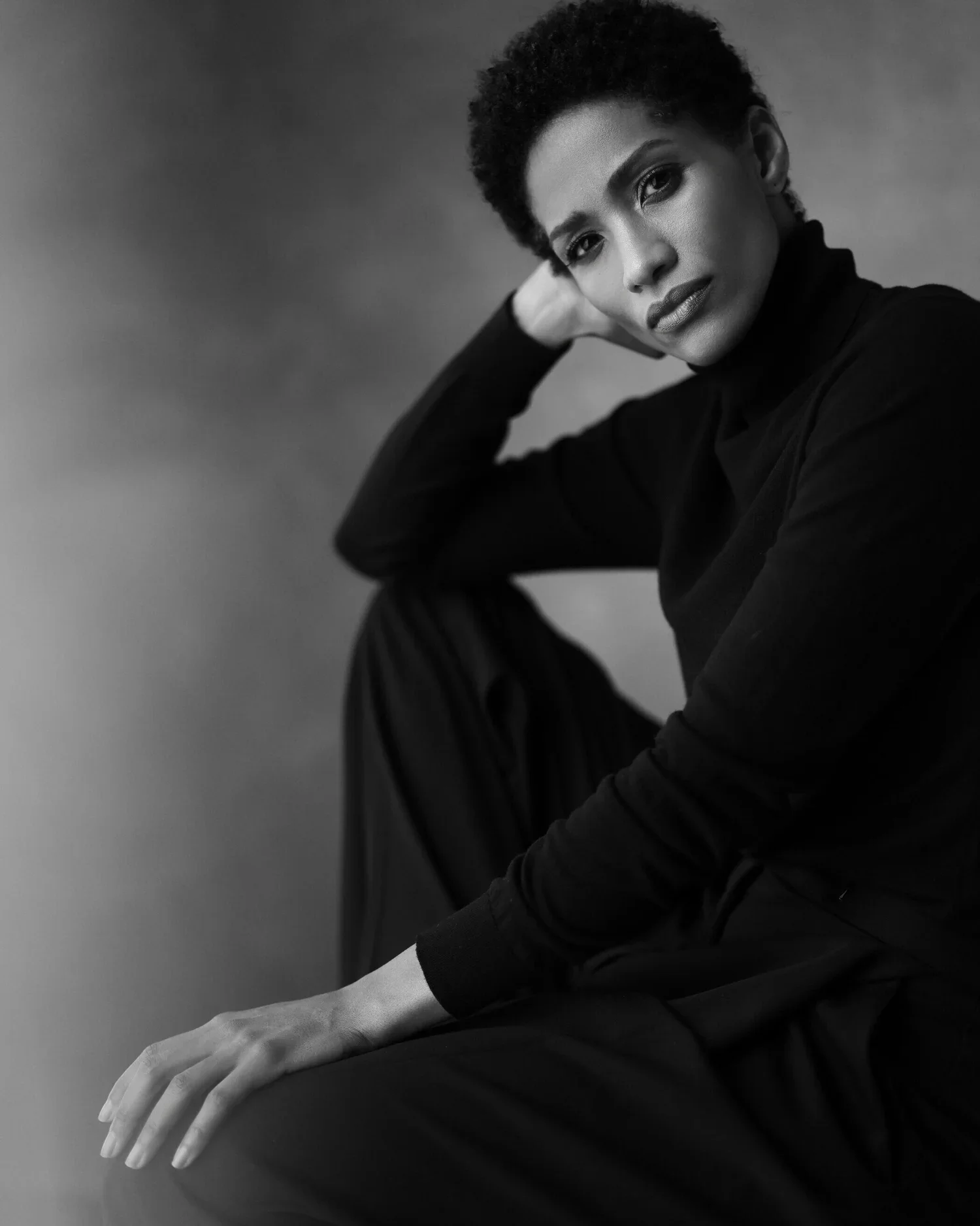Woman_in_Black_Turtleneck_Sitting_with_Hand_on_Chin.jpg.webp