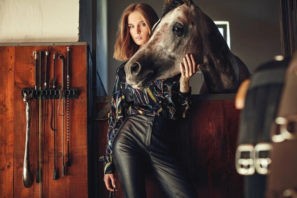 Woman_in_Colorful_Blouse_with_Horse_in_Stable.jpg