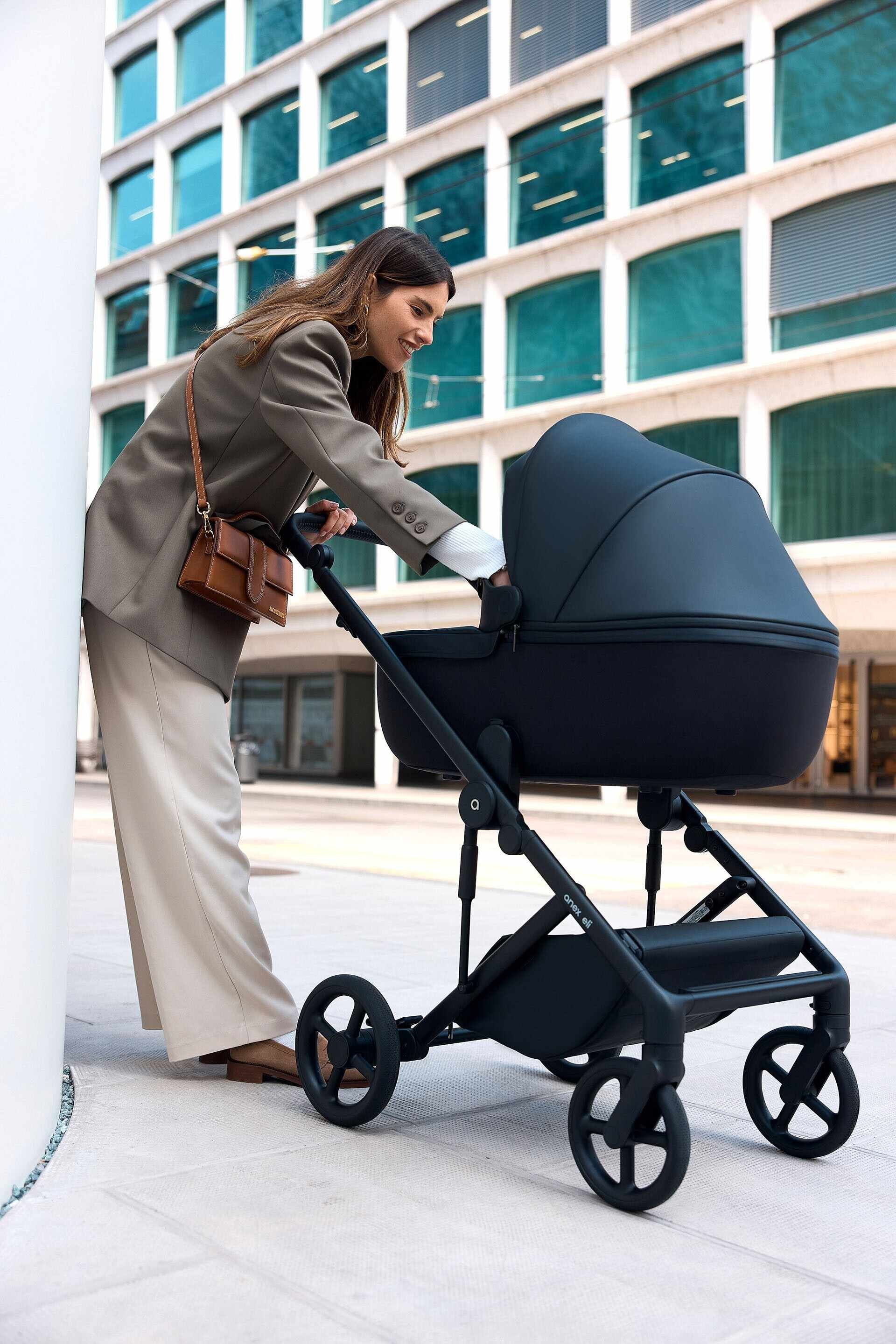 Woman_in_beige_suit_with_stroller_near_modern_building.jpg