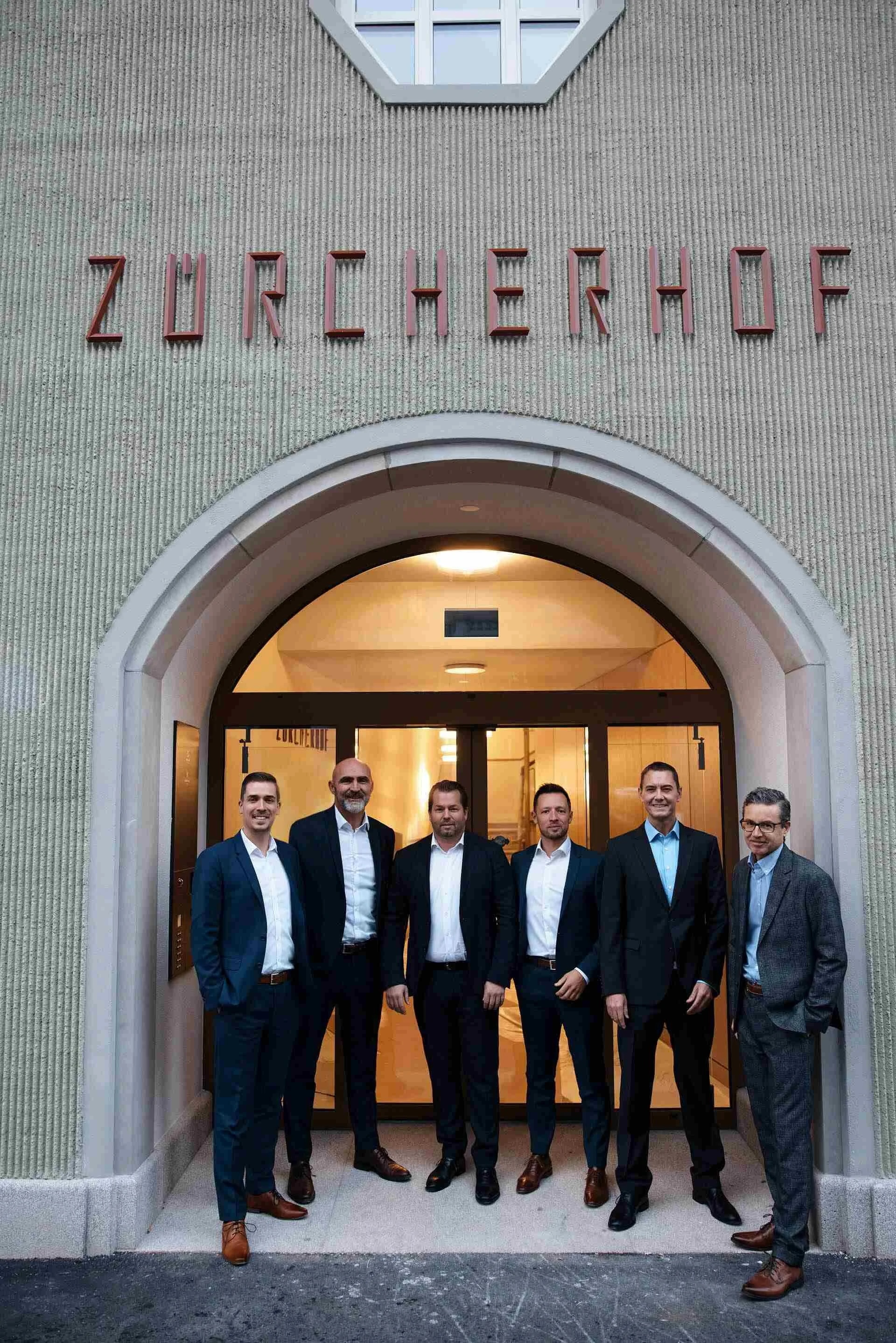 Group_of_Men_in_Suits_at_ZRCHERHOF_Entrance.jpg
