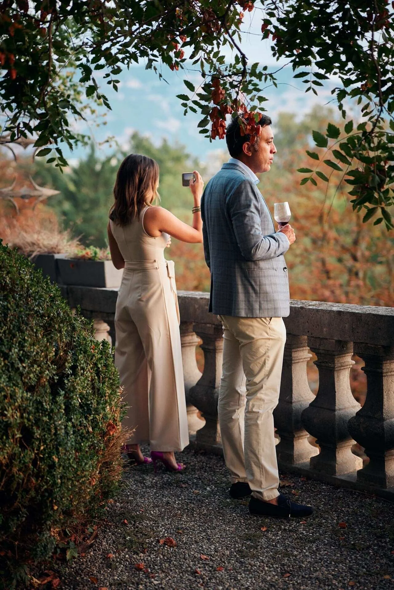 Couple_at_a_balcony_with_wine_and_camera_in_autumn_setting.jpeg