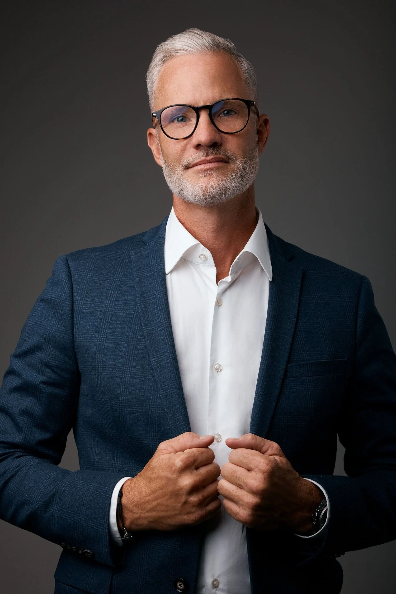Man_in_Blue_Suit_with_Glasses_and_White_Shirt.jpg