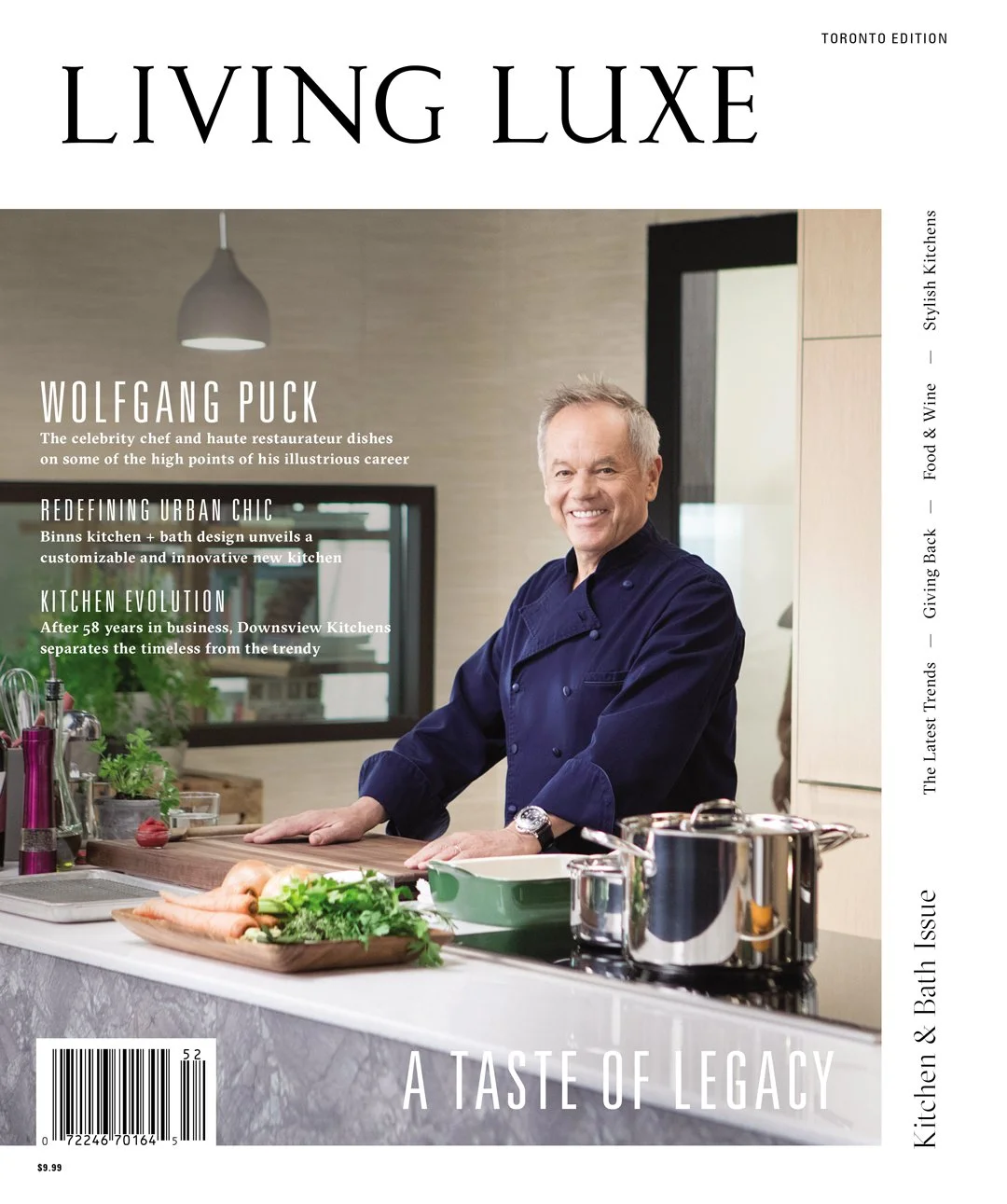 Cover of Living Luxe magazine featuring chef Wolfgang Puck in a modern kitchen, smiling and standing by a marble countertop with fresh vegetables and cookware