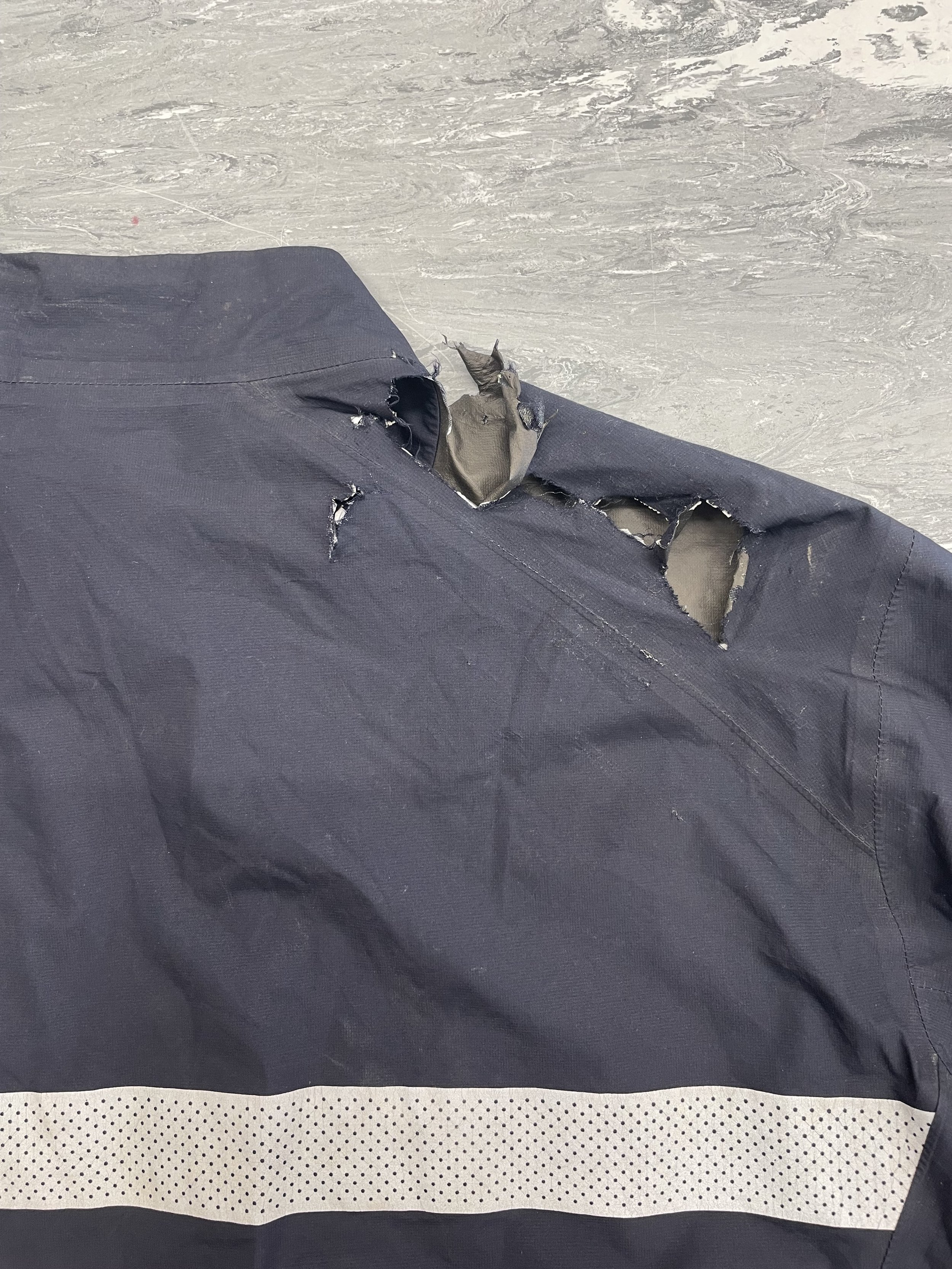 Severe tear to shoulder of Rapha coat, affecting waterproof quality