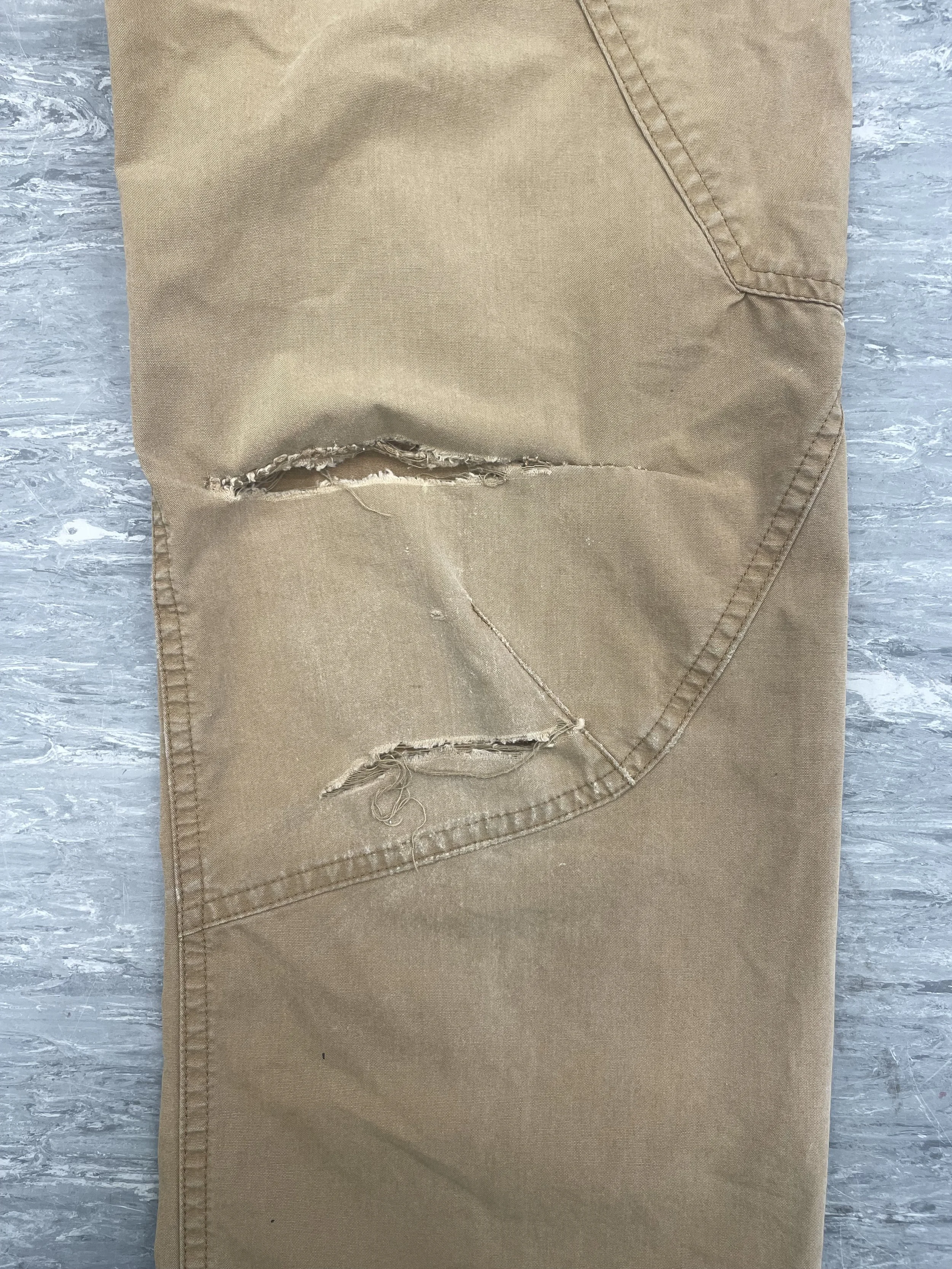 Multiple tears to knee area of Patagonia trousers, in high-stress area