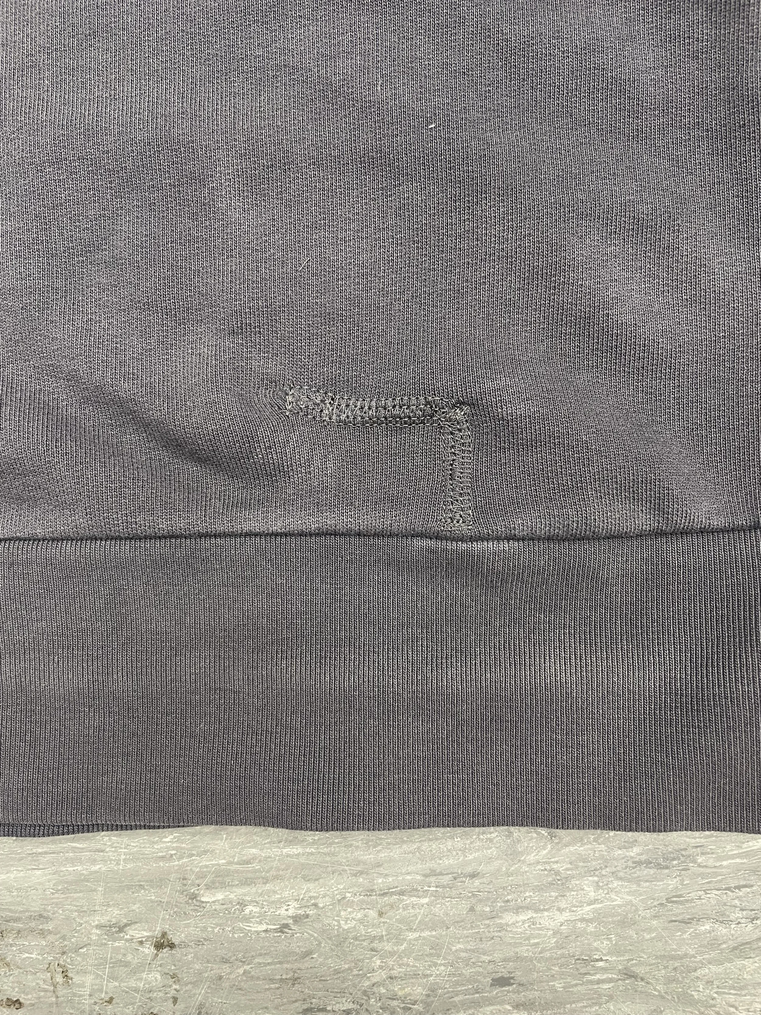 Hole hand-stitched closed and secured with flatlock stitching