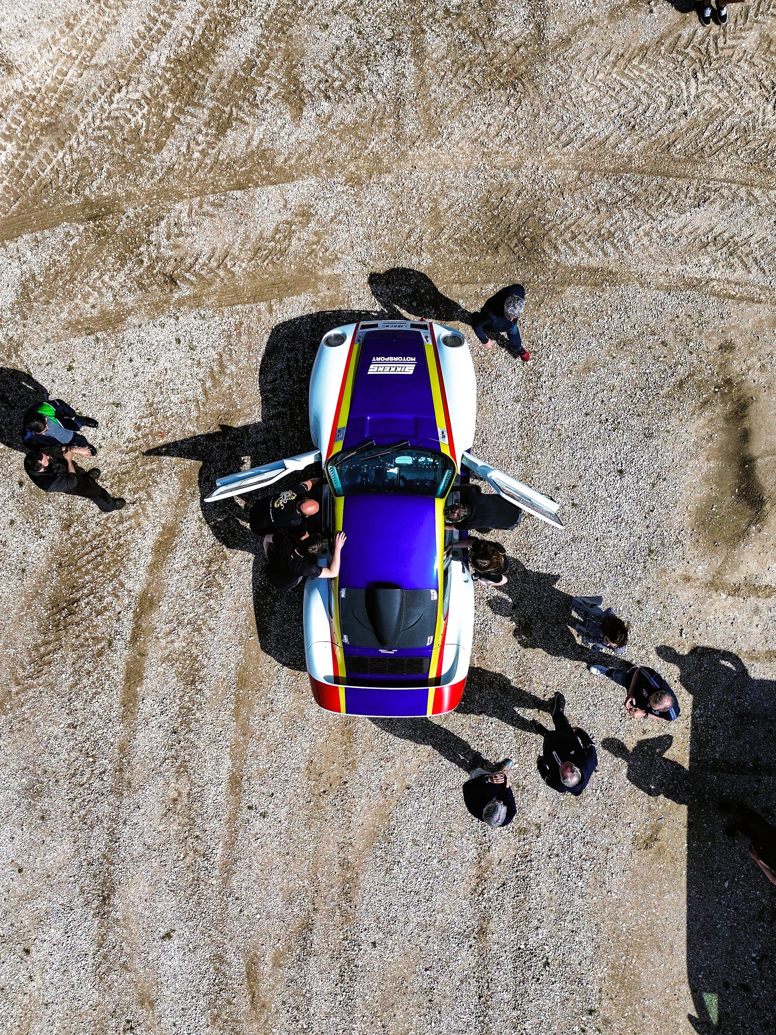 Aerial view of Sikkens Motorsport Dakar heritage project car surrounded by team during off-road testing stop