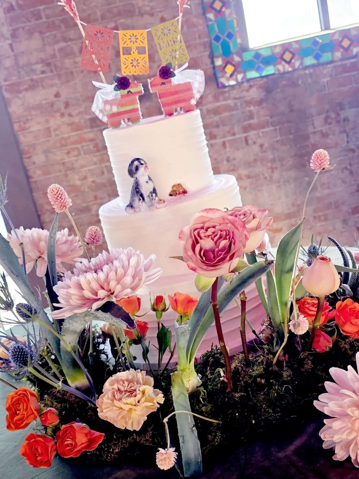 A wedding cake with so much personality 🤍
Clean, modern tiers paired with the sweetest papel picado banner, hand-crafted llamas, and a little pup stealing a bite 🐶✨
Finished with lush florals for the perfect blend of tradition, whimsy, and love&mda