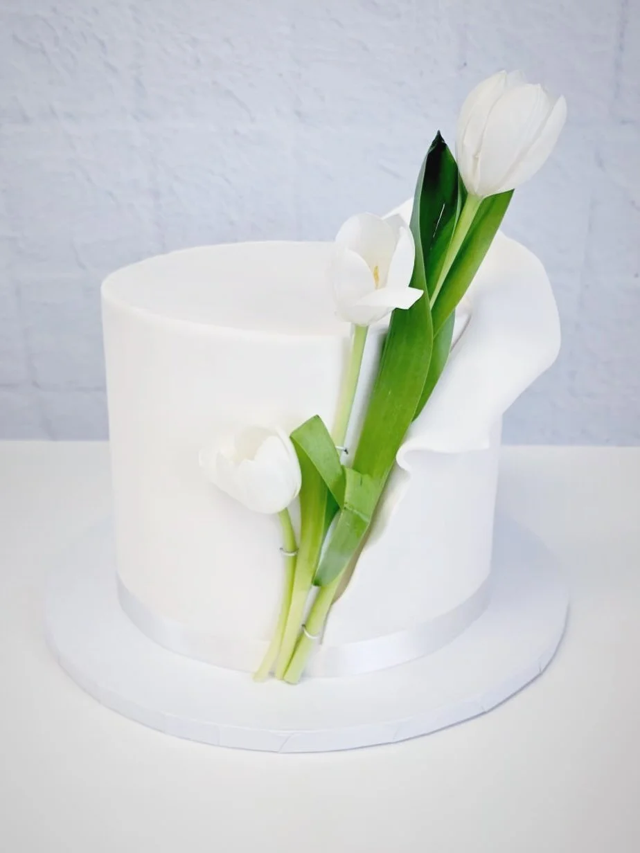 Simple and effortlessly romantic 🤍
This modern wedding cake paired with delicate tulips is the perfect touch of elegance for a timeless celebration. #WeddingCake #TulipCake #FloralWeddingCake #CustomCakesElPaso #WeddingCakesElPaso