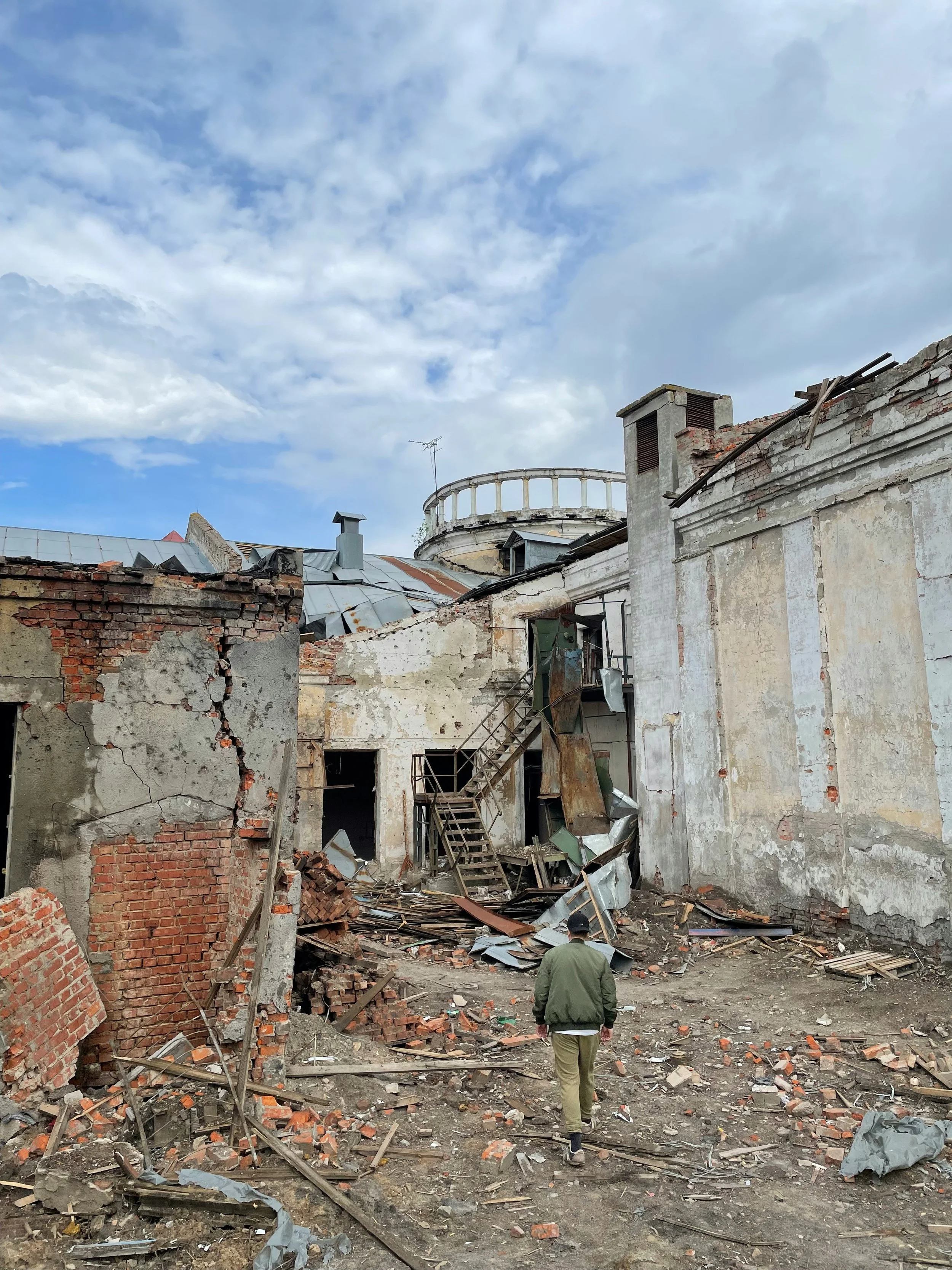 Man walking towards a destroyed building in Ukraine