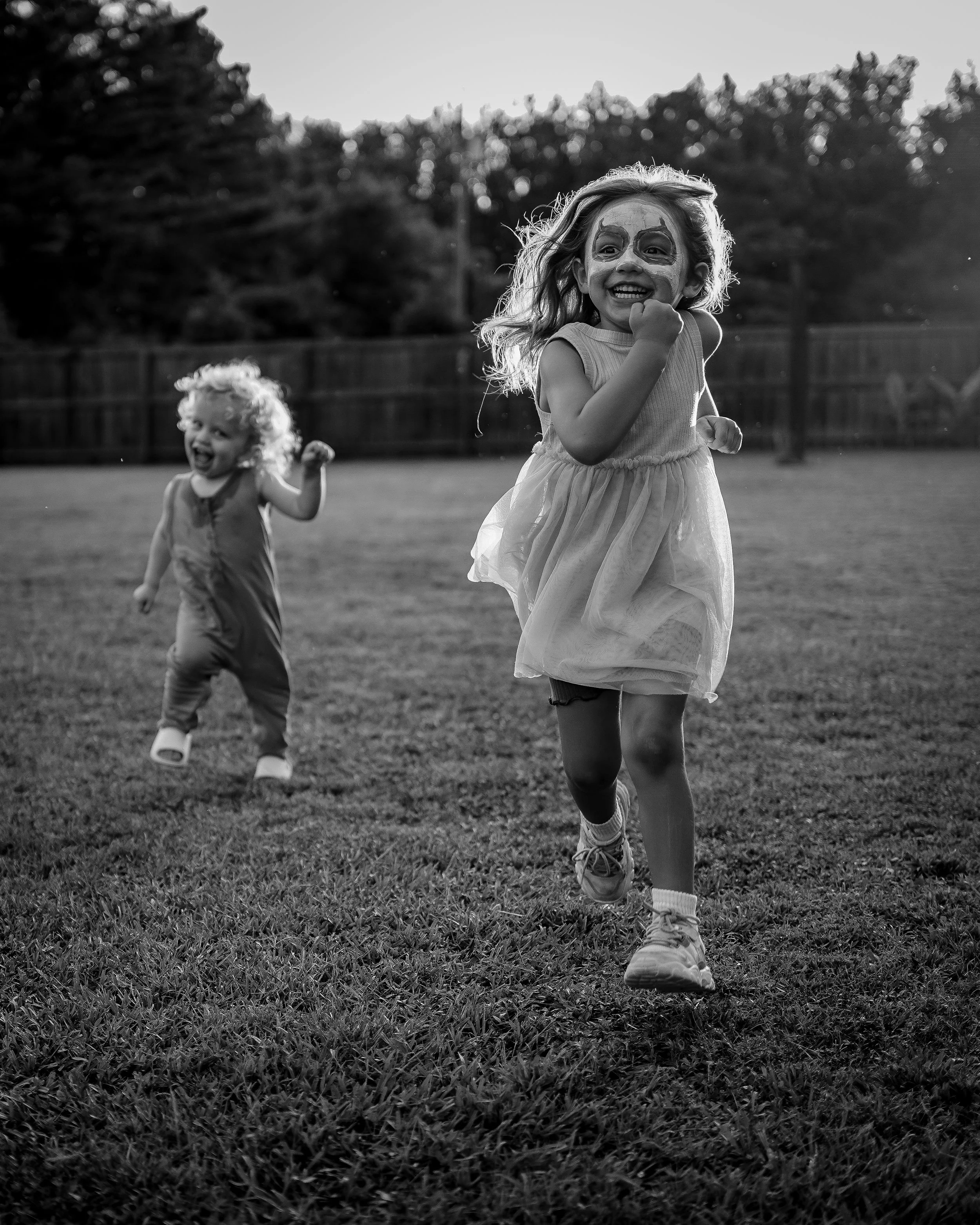Two siblings running together during a family photoshoot in Alabama