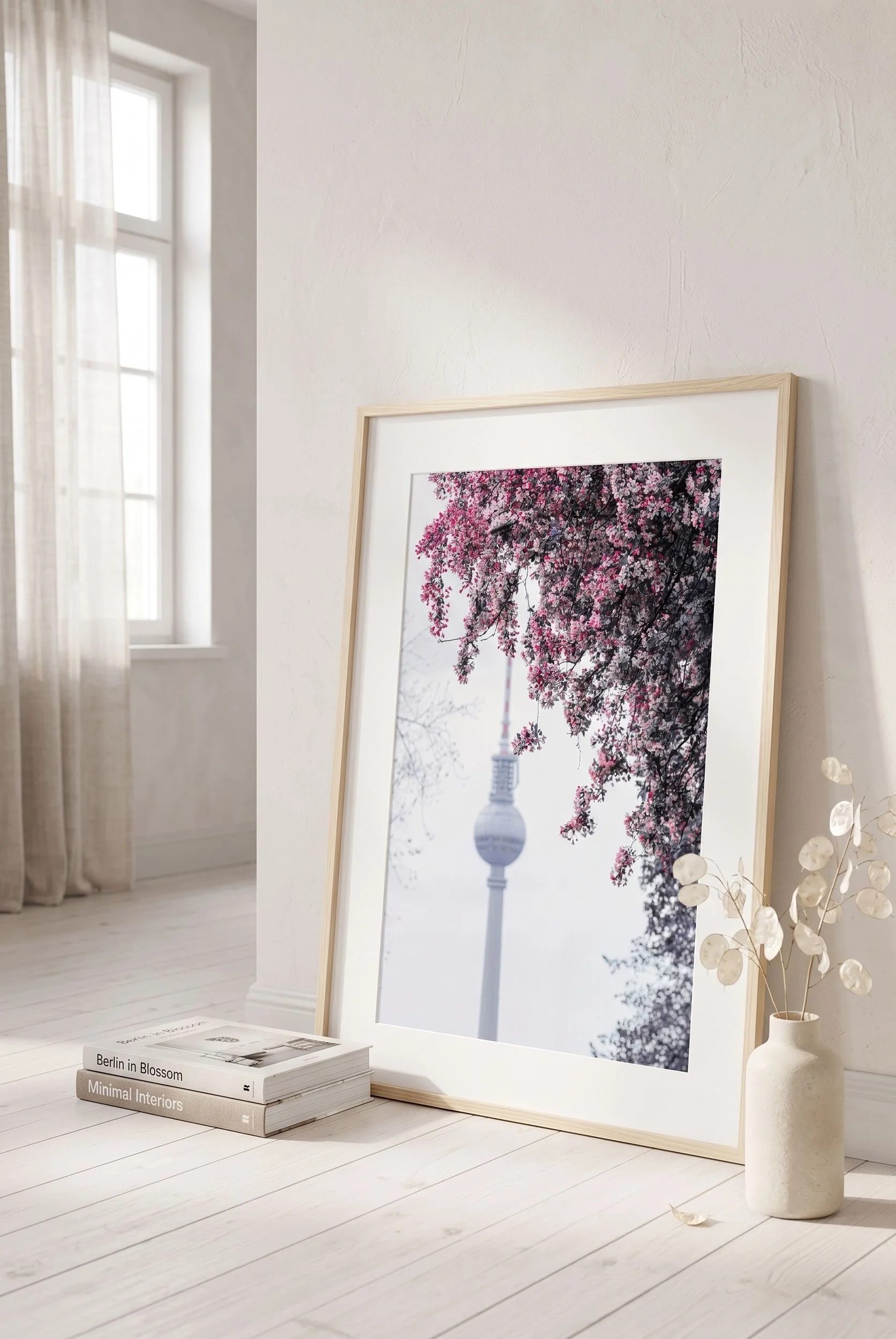 Cherry blossom print leaning on a shelf with soft natural light in a minimal interior.
