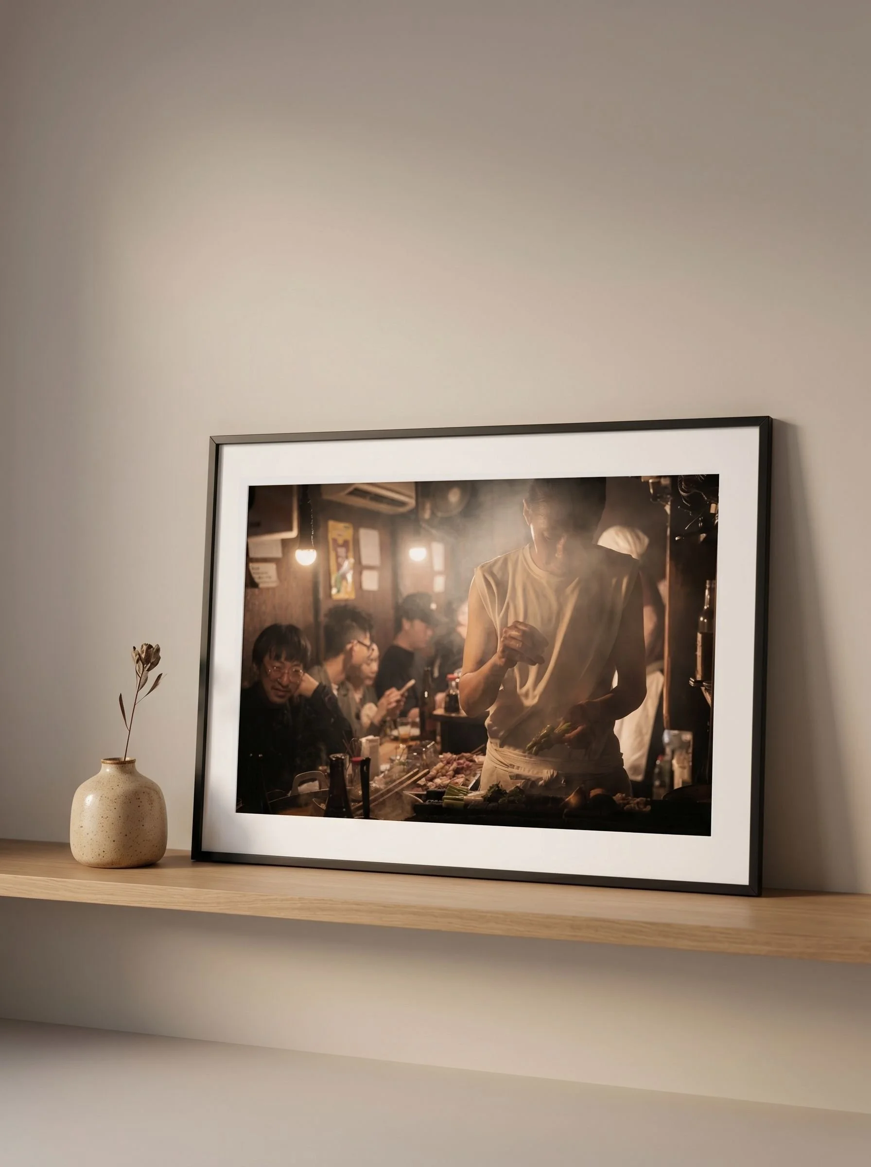 Landscape izakaya cooking print in a black frame above a walnut sideboard.