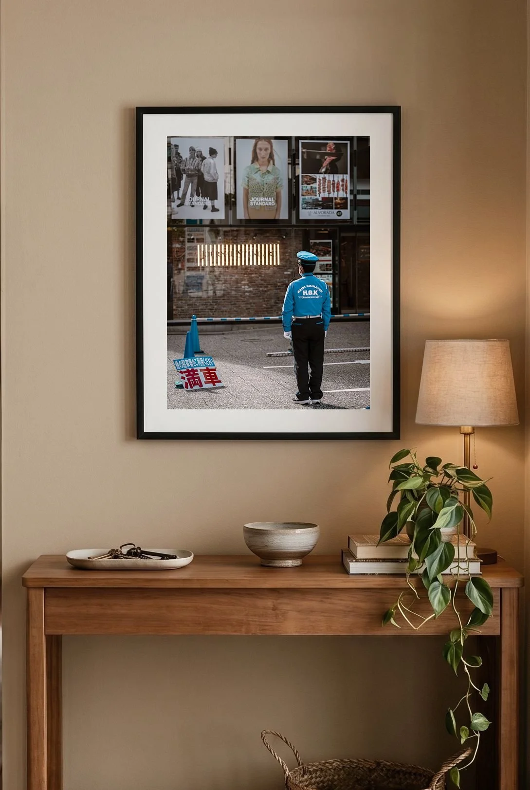 Hiroshima street print in a black frame above an olive wall and leather chair.