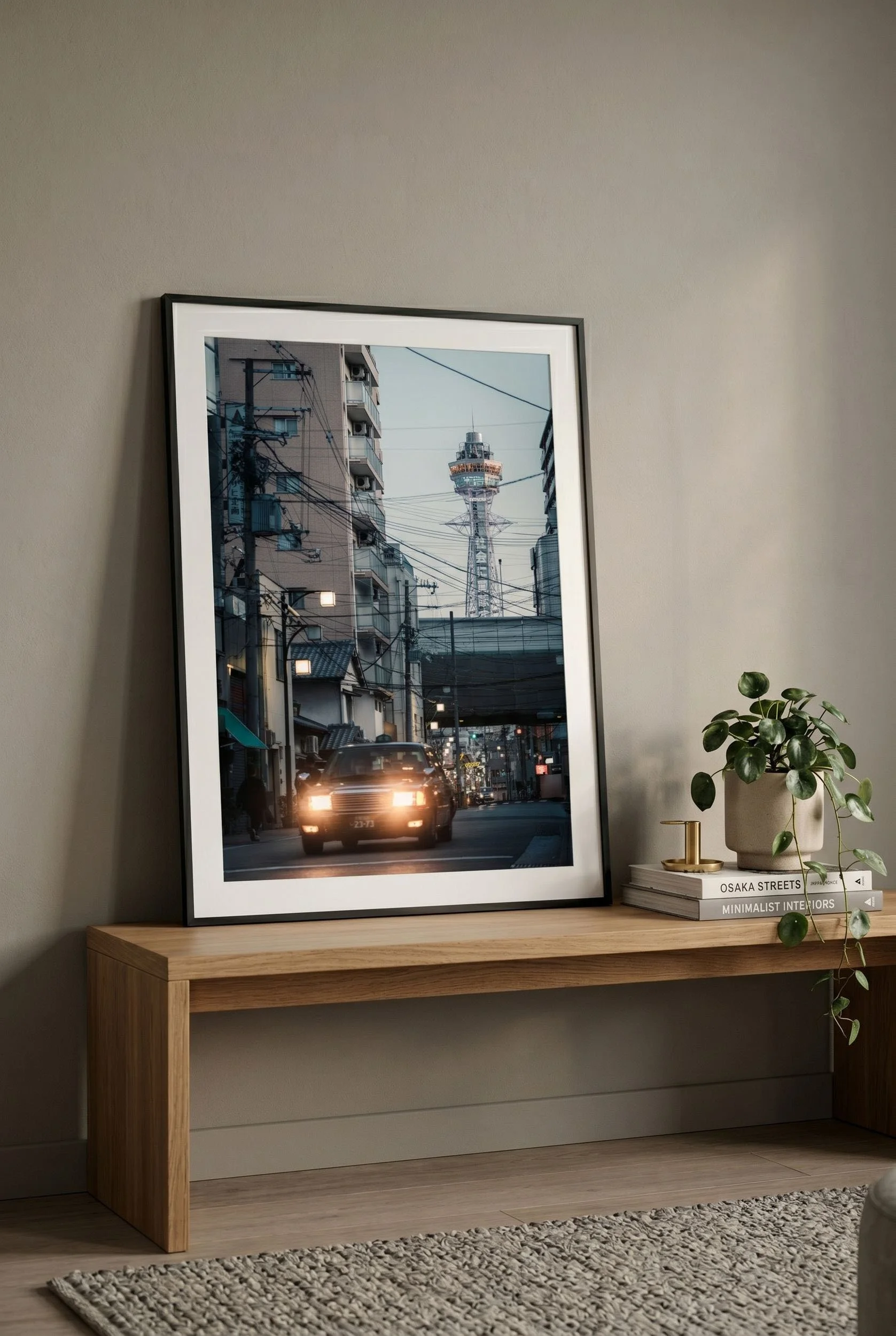 Tsutenkaku Tower print with table lamp in a warm wood interior.