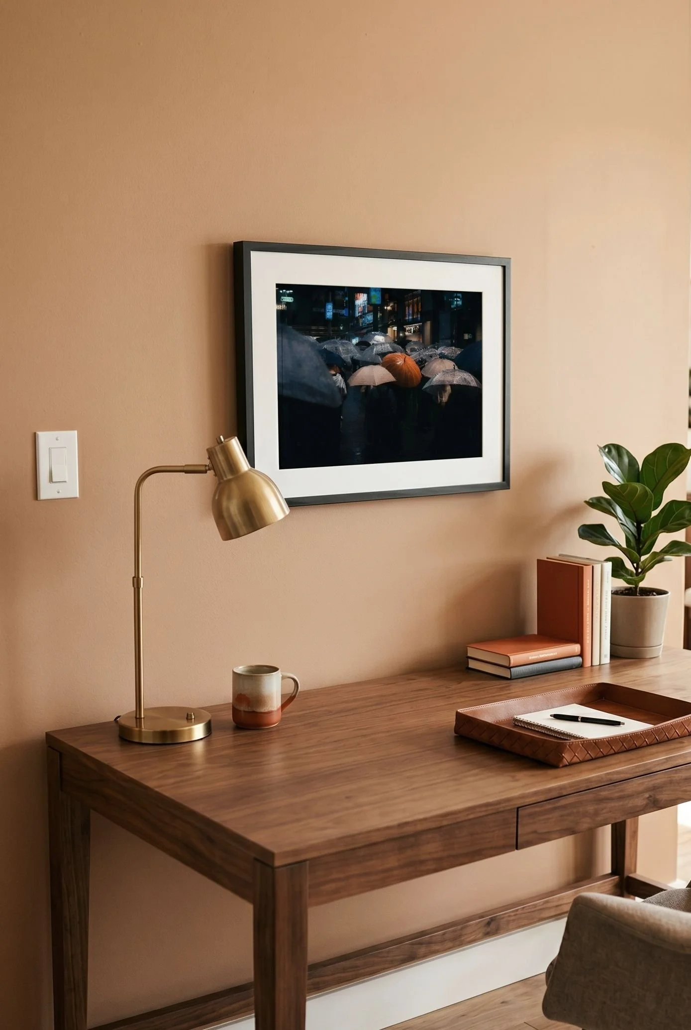 Shibuya rain print hung above a desk in a warm, terracotta-toned room.