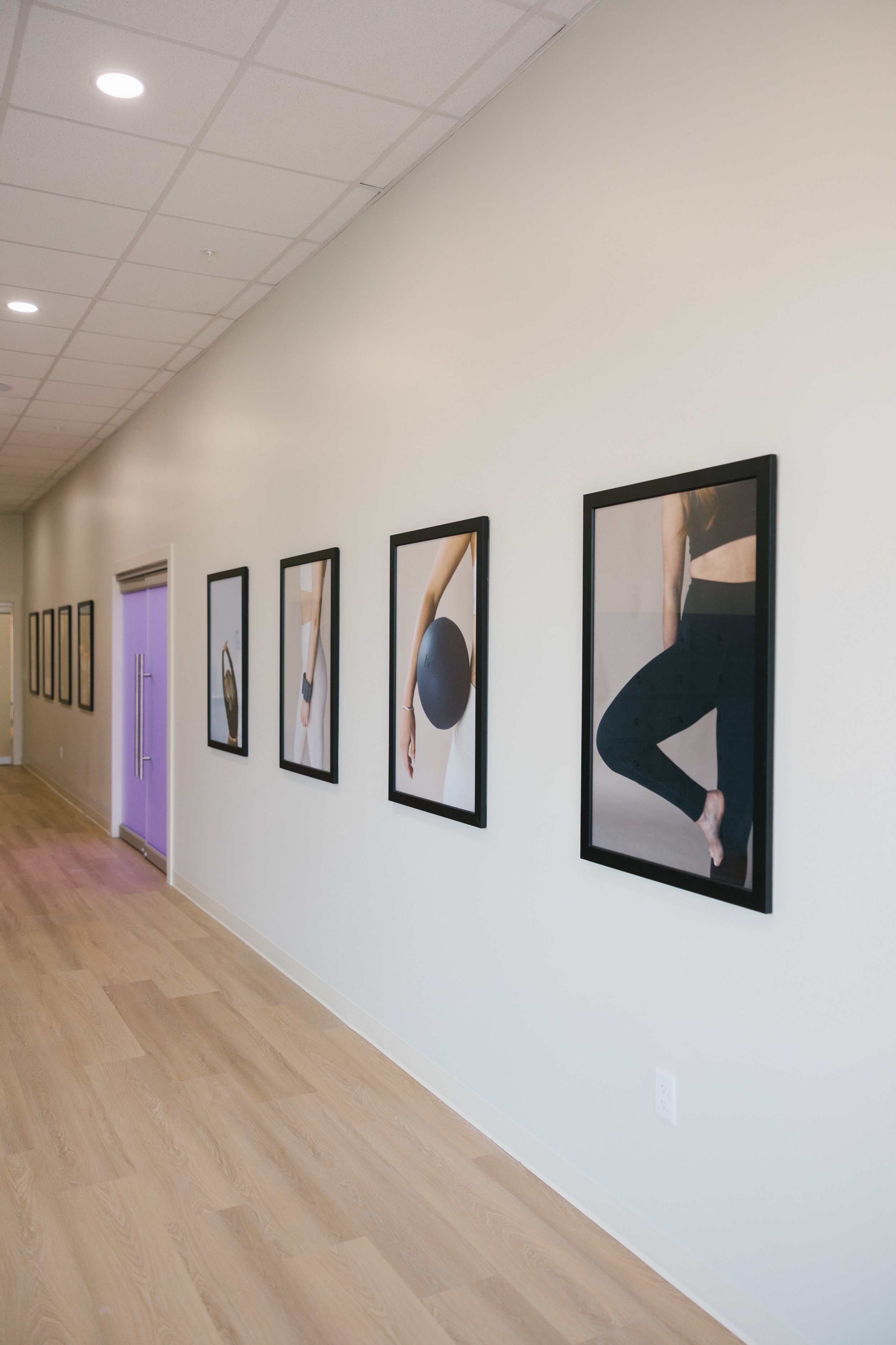 Gallery wall with fitness and yoga-themed photographs in frames.