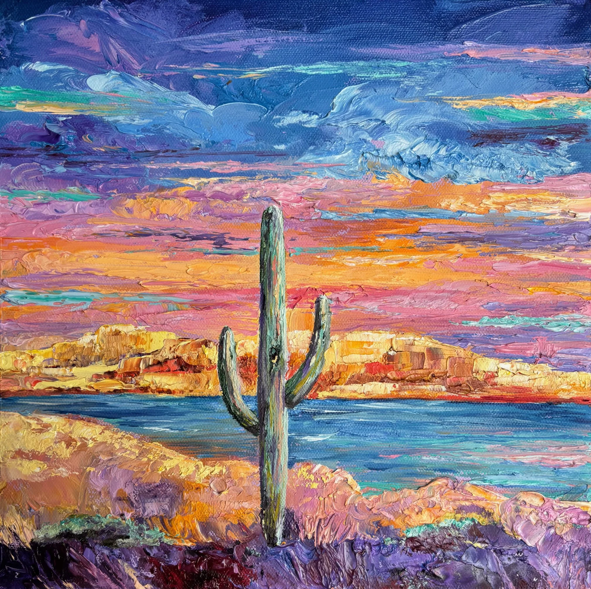 Painting of a desert scene with a tall cactus in the foreground, a body of water, and pink, purple, and orange sky at sunset.