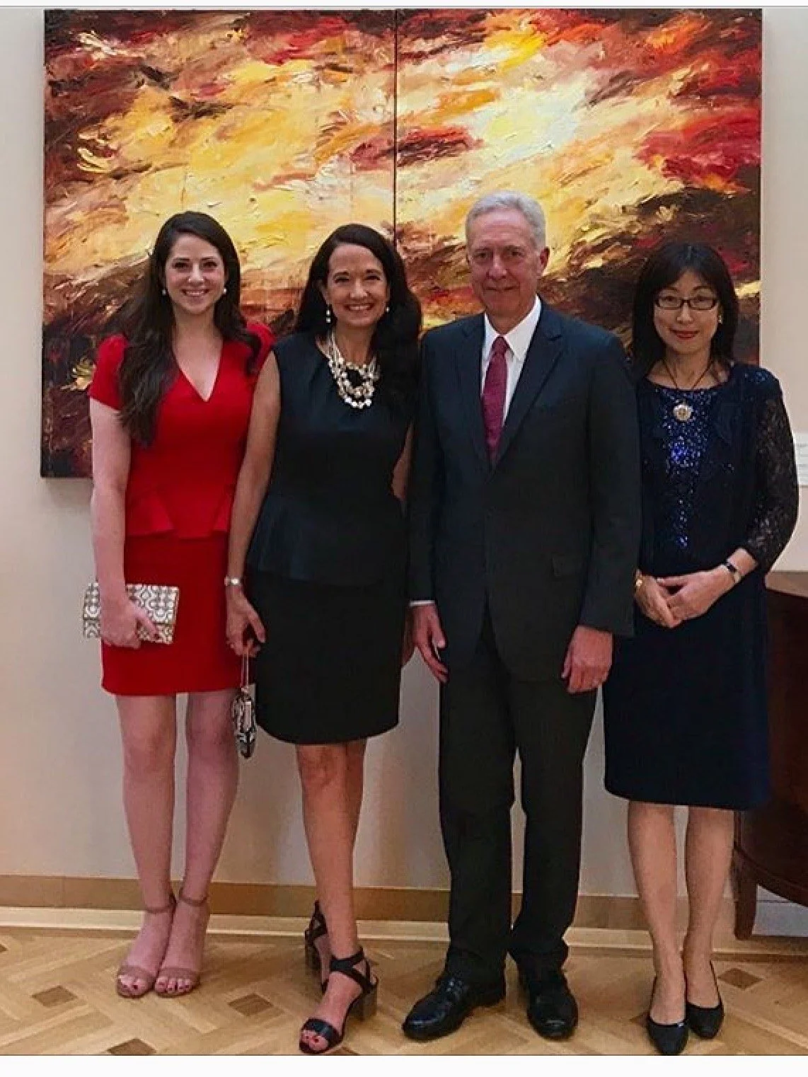 Karen and her daughter Caitlin standing beside Ambassador Hans Klemm and his wife Mari in front of Karen's painting Resurrection at the US Embassy in Bucharest, Romania.