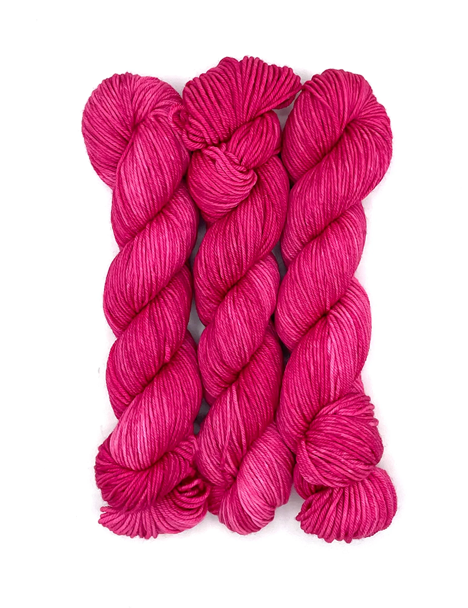 three hot pink yarn skeins