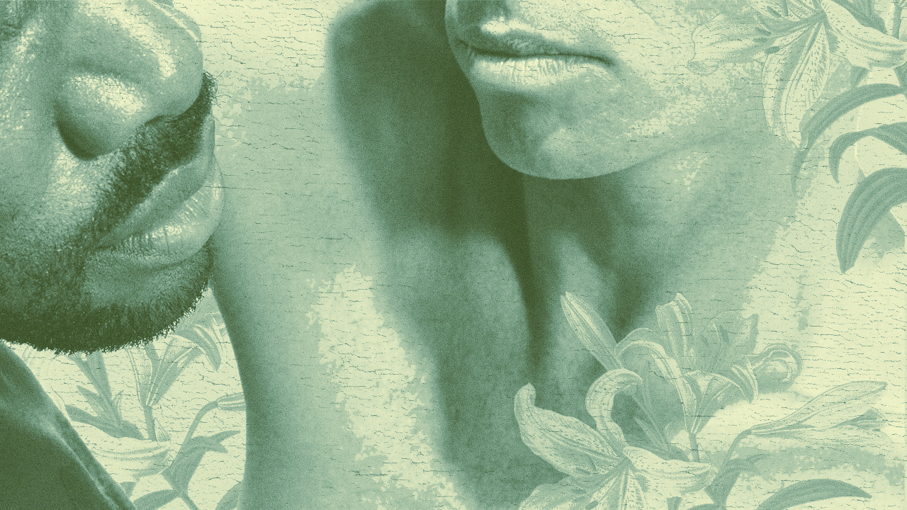 Close-up of two people's faces with their lips near each other, surrounded by a background of leafy plants.