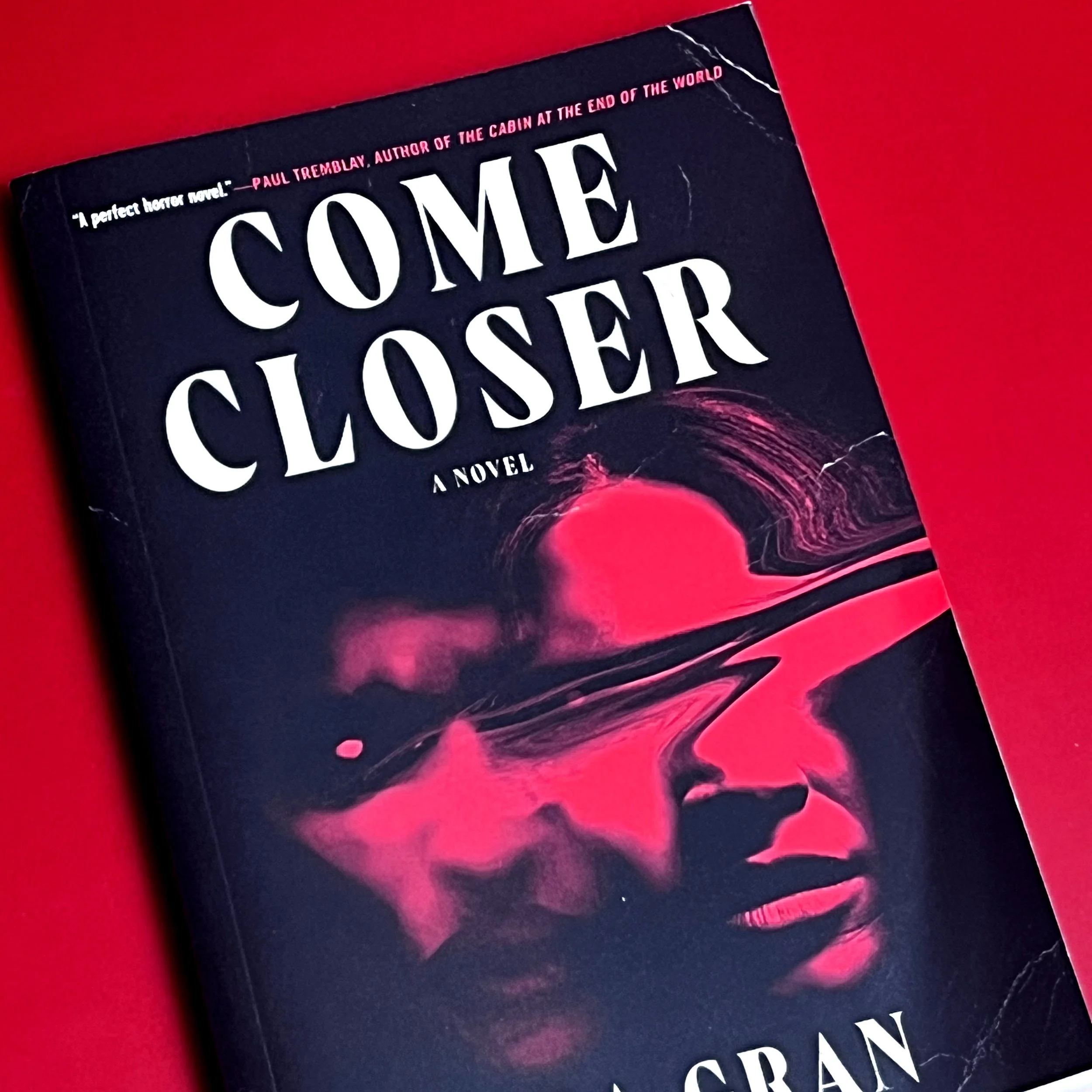 Up close image of book cover, showing the crease at the top right corner and mild warping of cover corner.