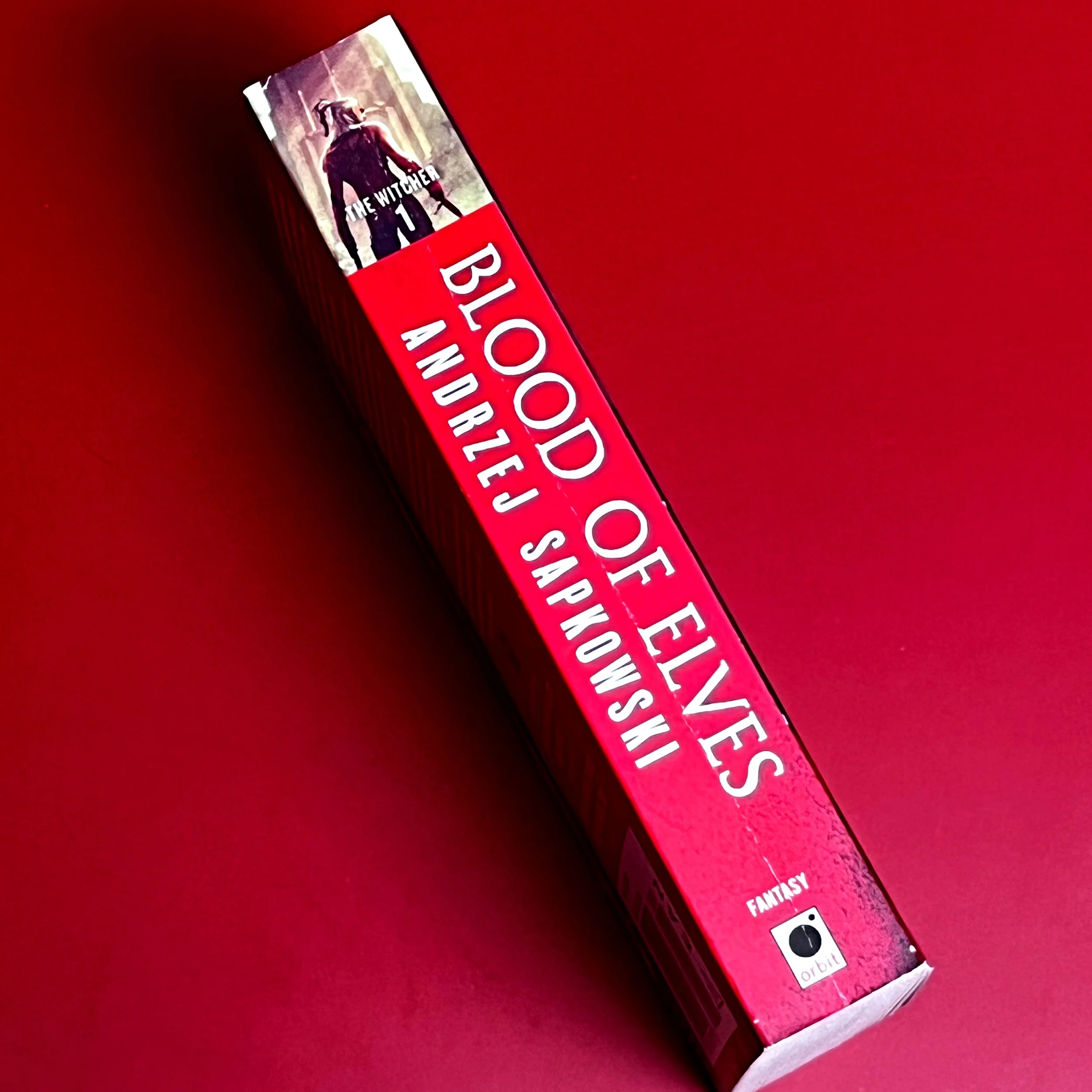 Spine of paperback with mild cracking: red spine.