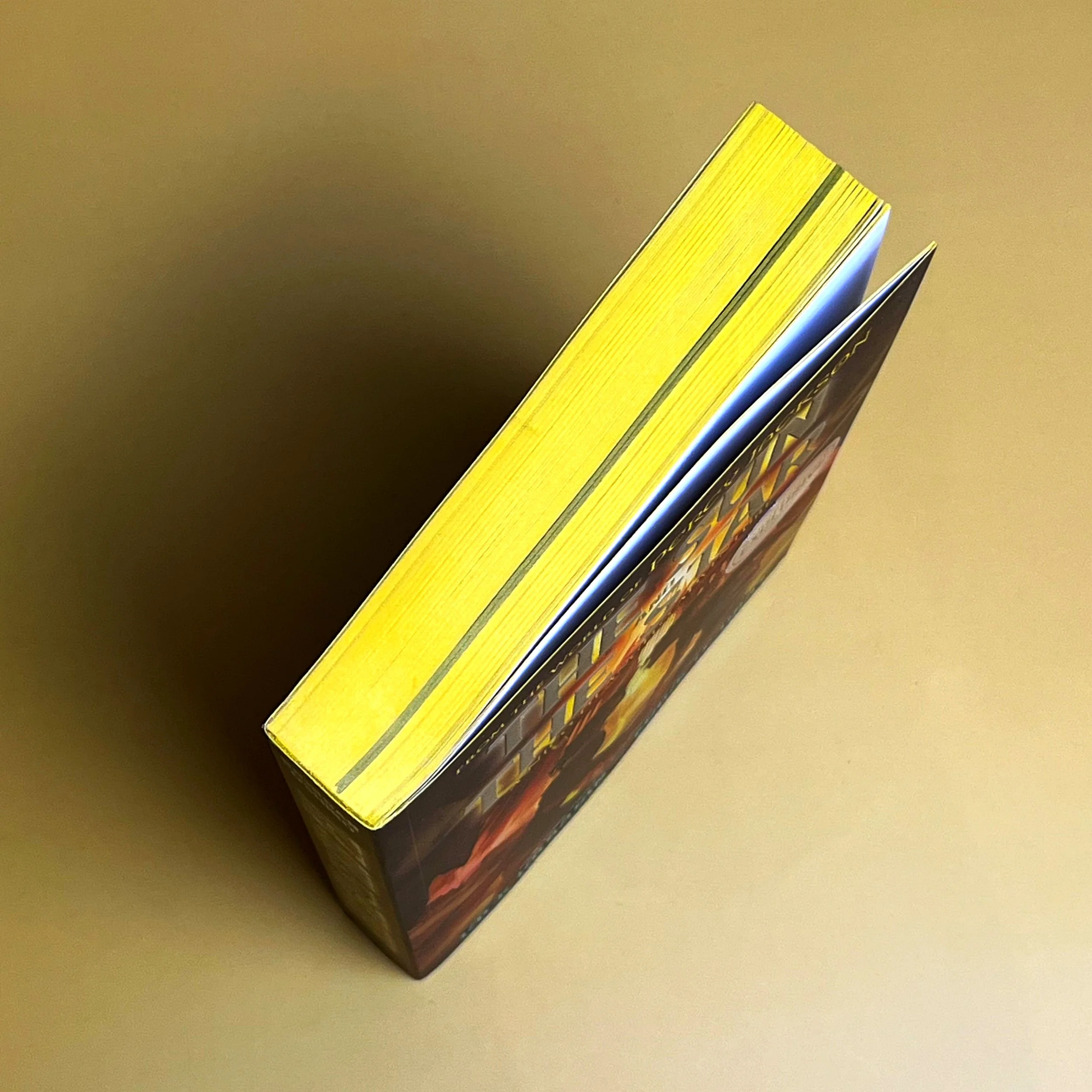 Yellow sprayed edges on paperback book with a small section sprayed black.