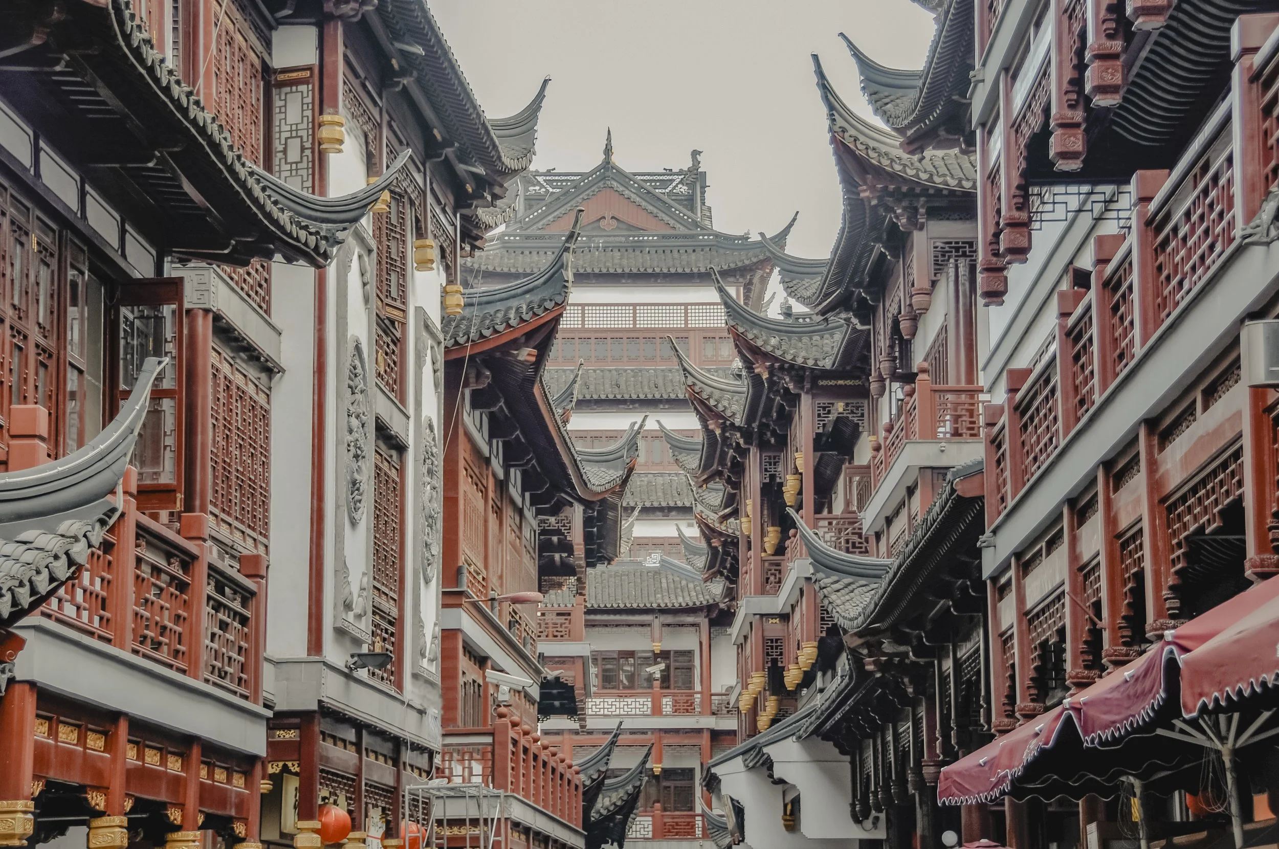Traditional Chinese-style streets with red wooden buildings and ornate, curved rooflines.