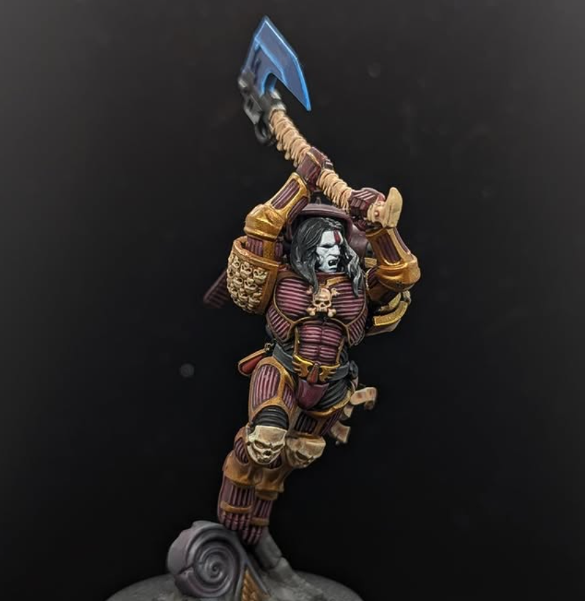 Detailed miniature figurine of a warrior with tribal and fantasy elements, wielding a large axe, standing on a decorative base, against a black background.