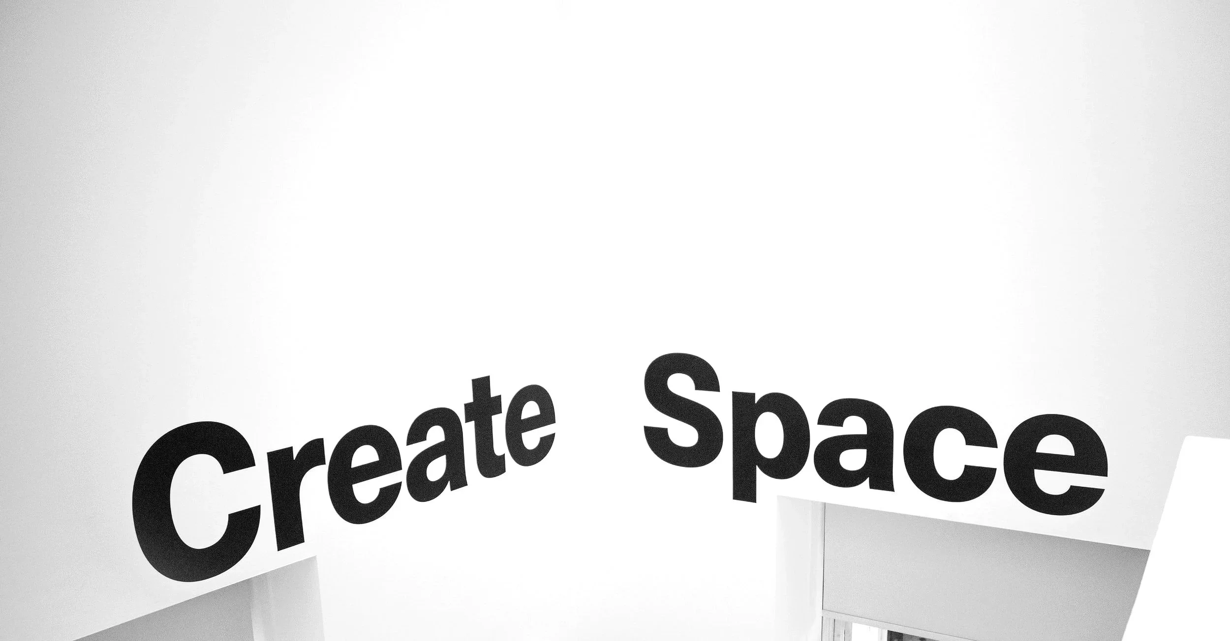 White wall with black text that says 'Create Space'.