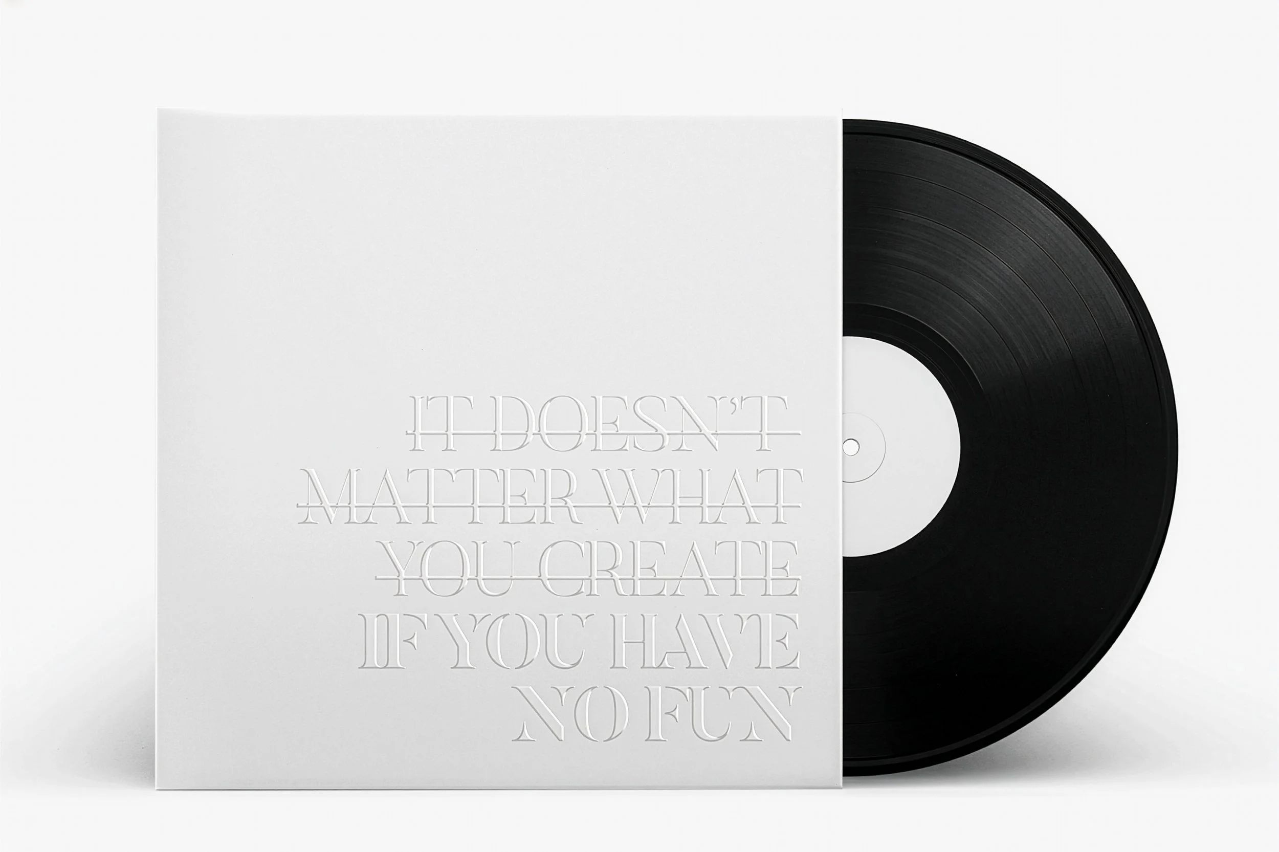 A vinyl record partially covered by a white paper sleeve with embossed text that reads, 'IT DOESN'T MATTER WHAT YOU CREATE, IF YOU HAVE YOU HAVE YOU.'