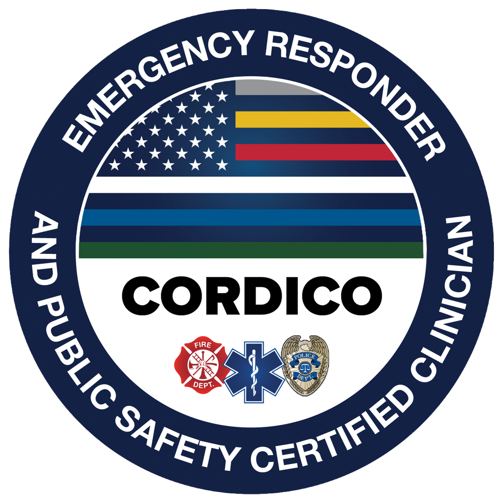 A circular badge with the words 'Emergency Responder and Public Safety Certified Clingan' surrounding a flag-inspired design. The flag design includes the American flag, a yellow-and-black striped flag, a red-and-blue striped flag, a white-and-blue striped flag, and a green-and-white striped flag. The center features the word 'CORDICO' in bold black letters, with icons of a firefighter, a medical emergency symbol, and a police badge below.