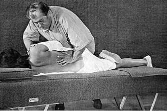 A man performing CPR on a woman lying on a mat