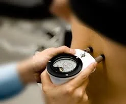Person using a handheld device for skin speed testing on their arm.