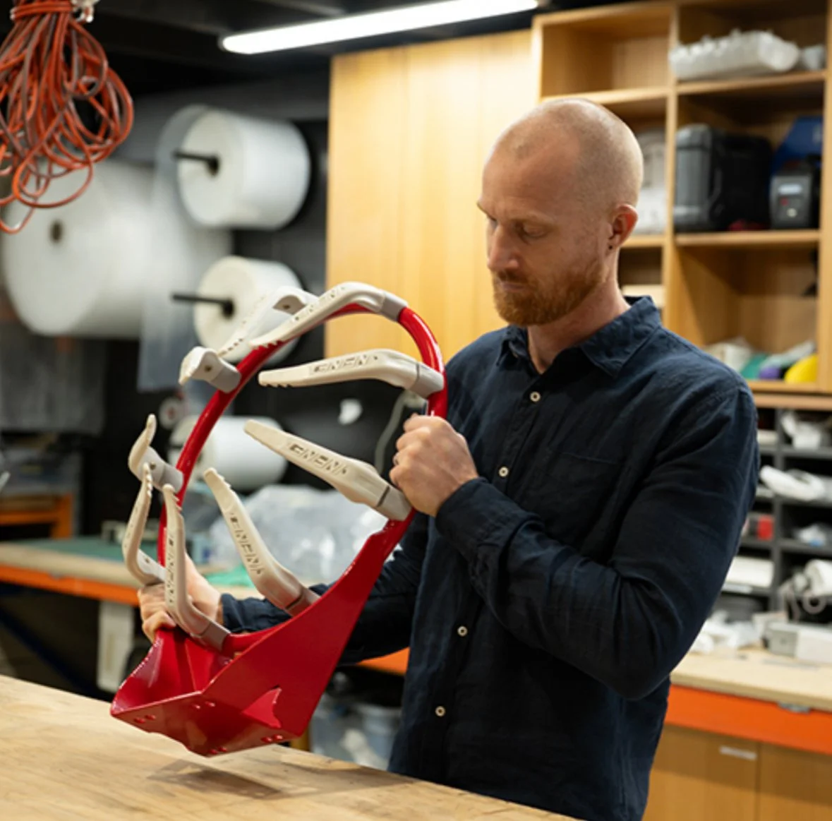 A man working with an Infinet basketball ring in a factory