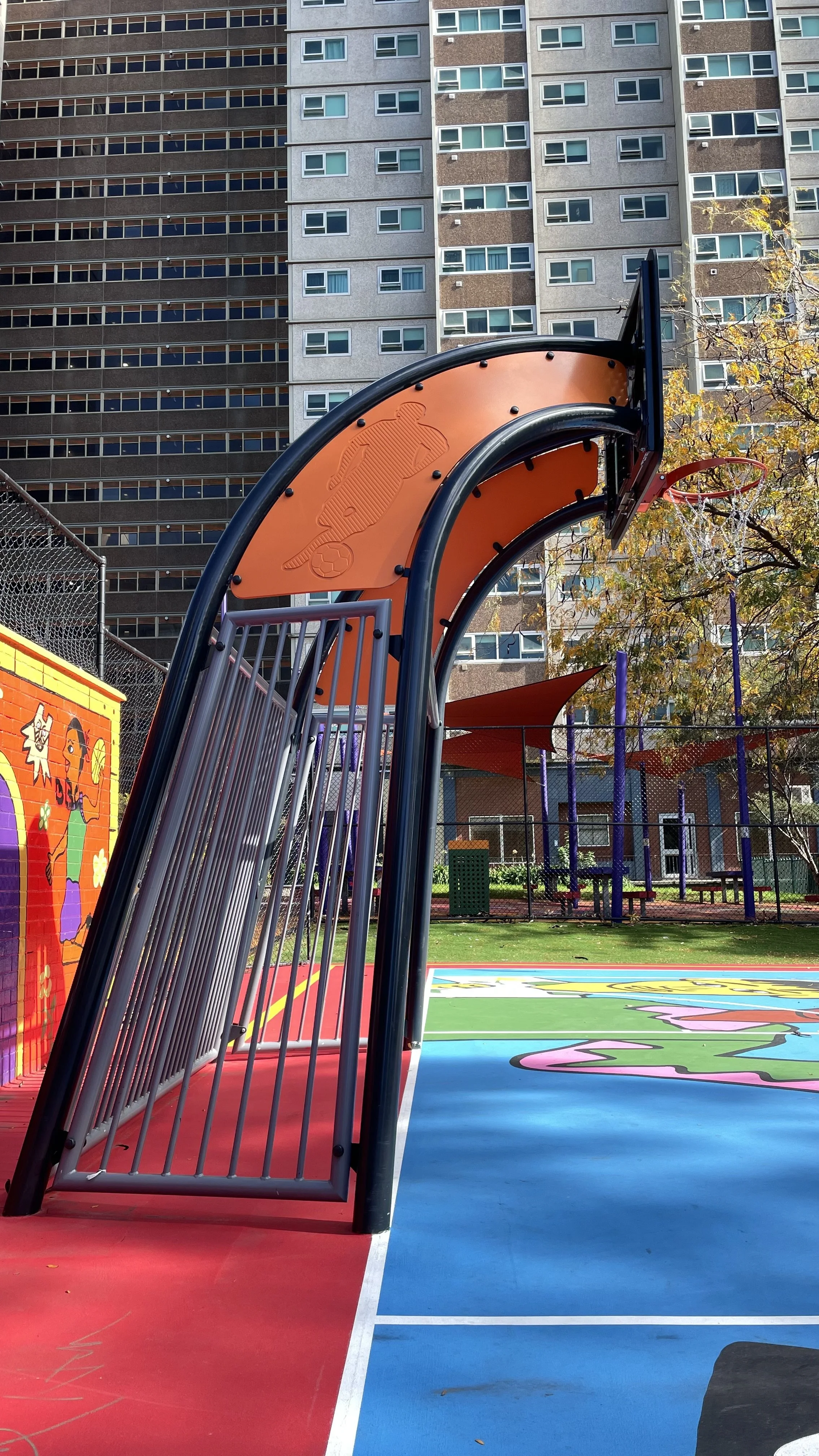 Fusion basketball tower with a city apartment building in the background.