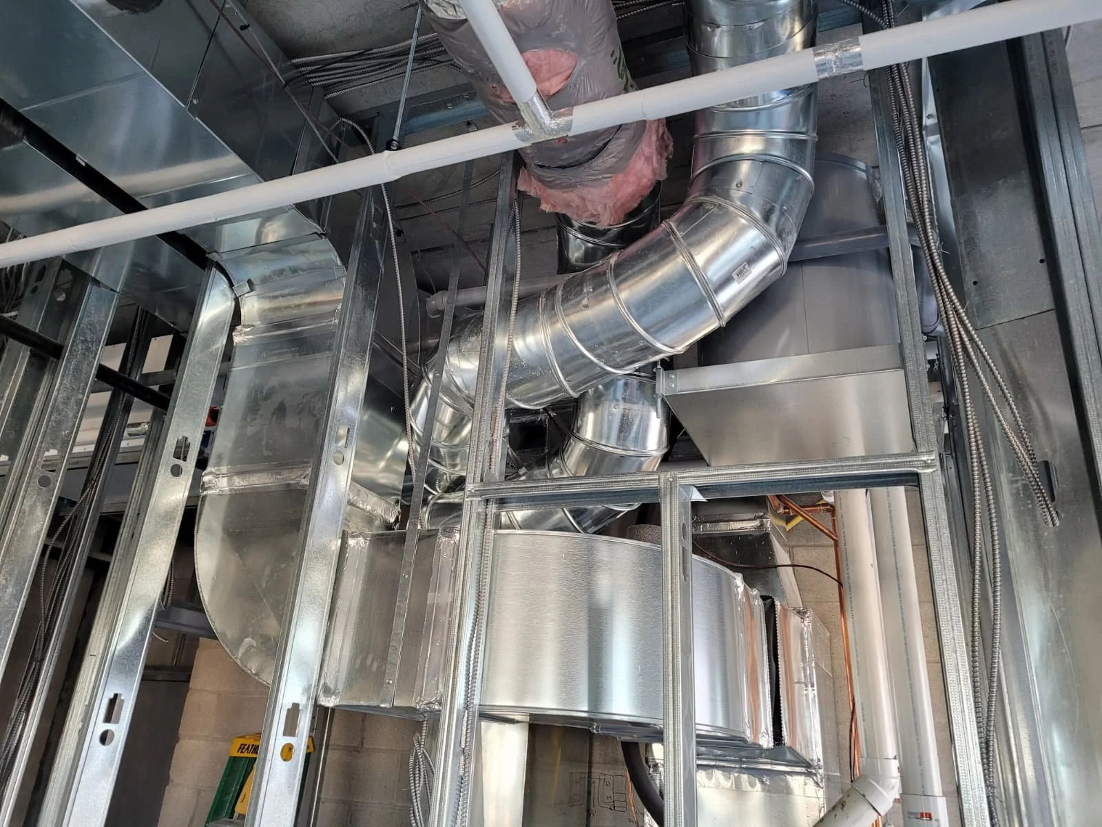 Interior view of a commercial HVAC system with stainless steel ducts and framing.