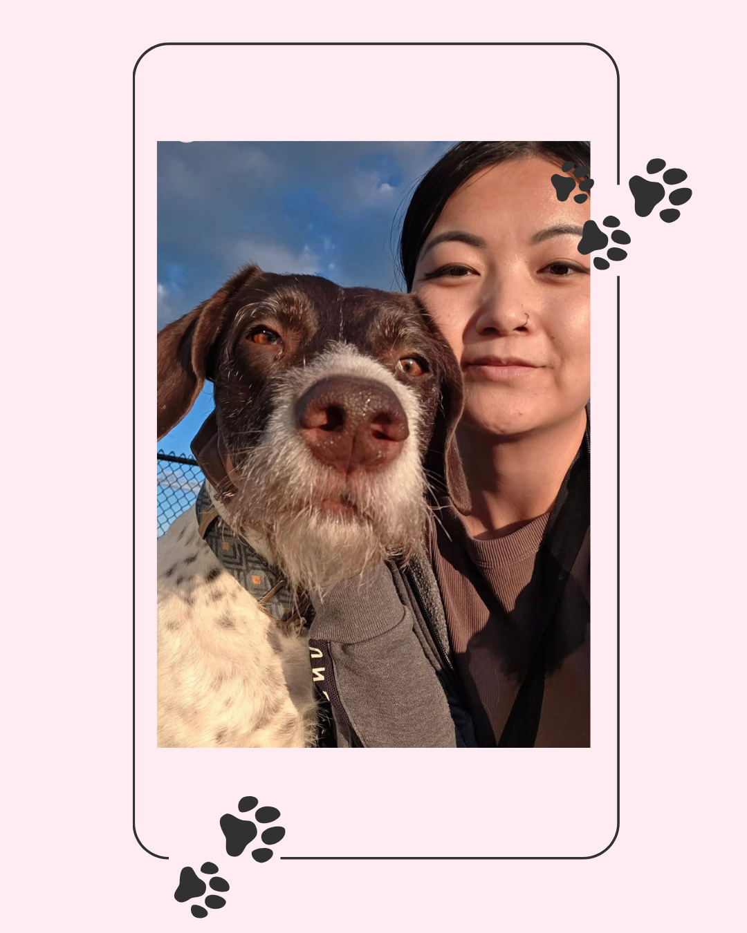 A woman taking a selfie with her dog outdoors during sunset.