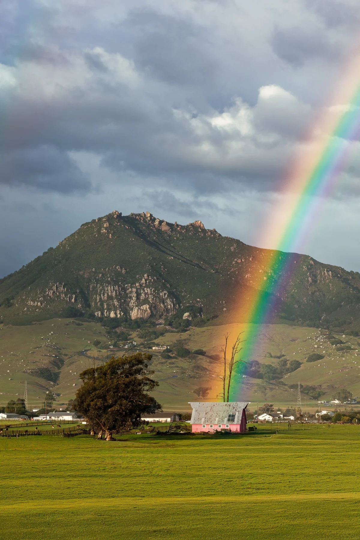 Rainbow landing on the pink barn in Los Osos Valley with Bishop Peak in the background