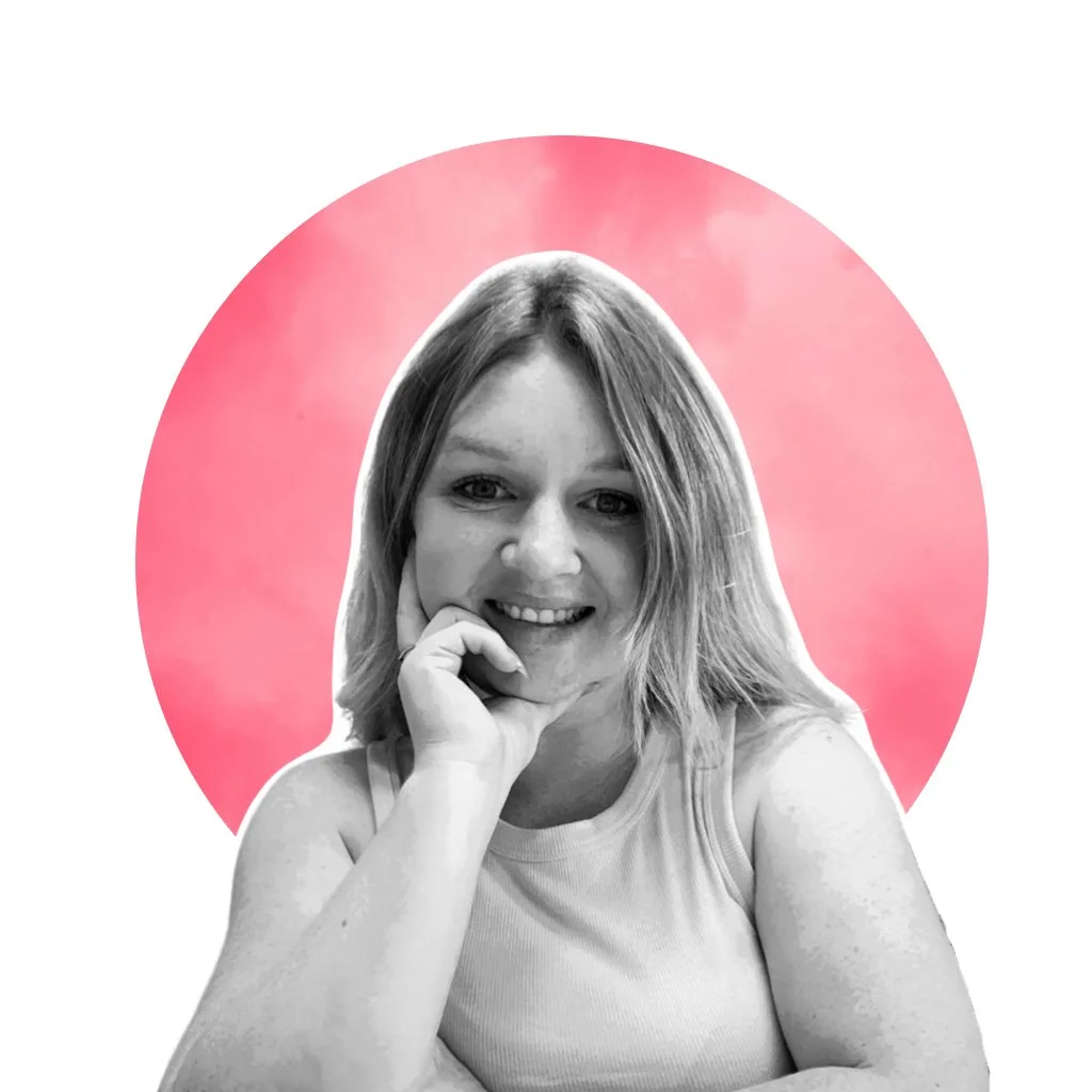 Black and white photo of a smiling woman with shoulder-length hair resting her chin on her hand, in front of a pink watercolor circle background.